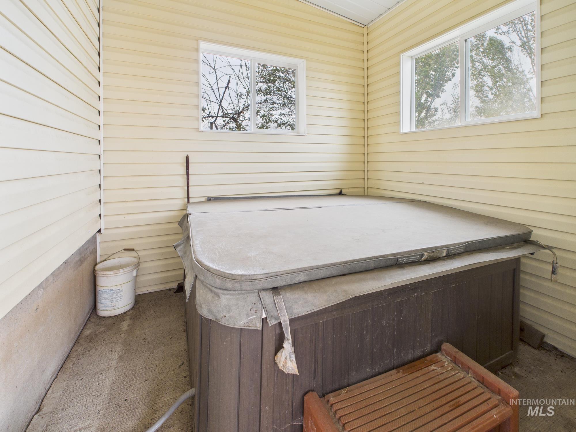 Miscellaneous room featuring a hot tub and wood walls