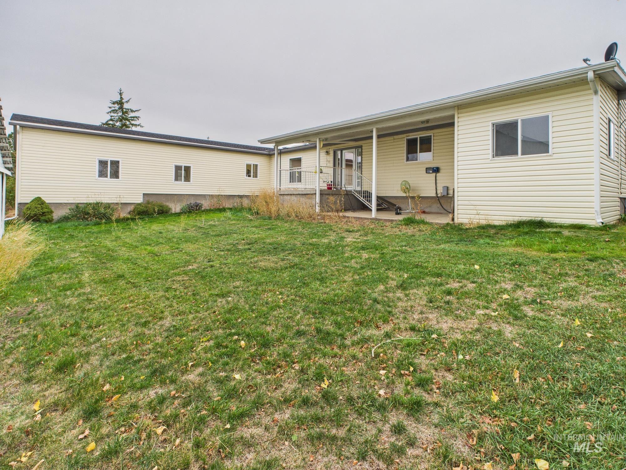 Back of house featuring a lawn and a patio