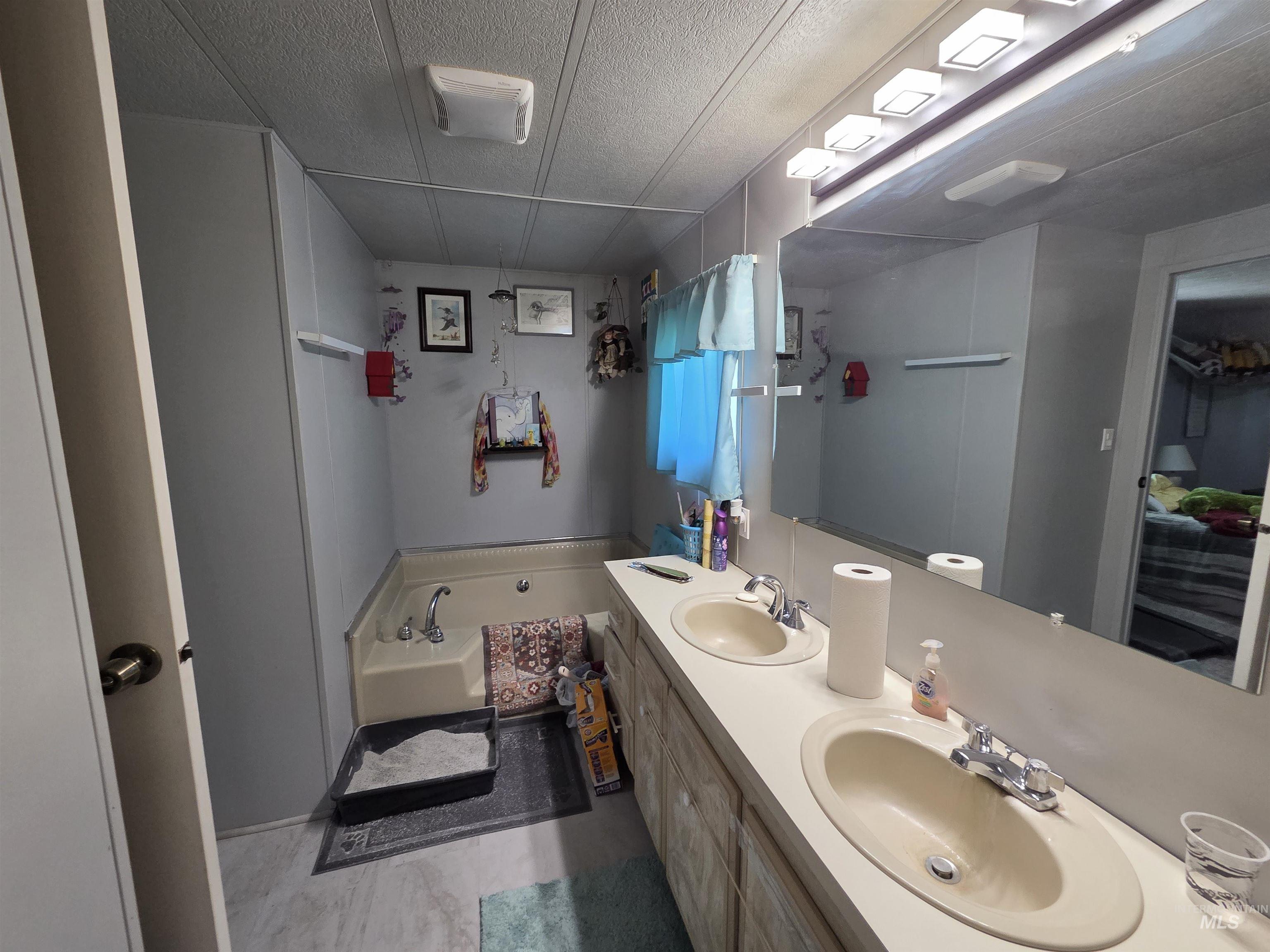 Bathroom featuring a garden tub and double vanity