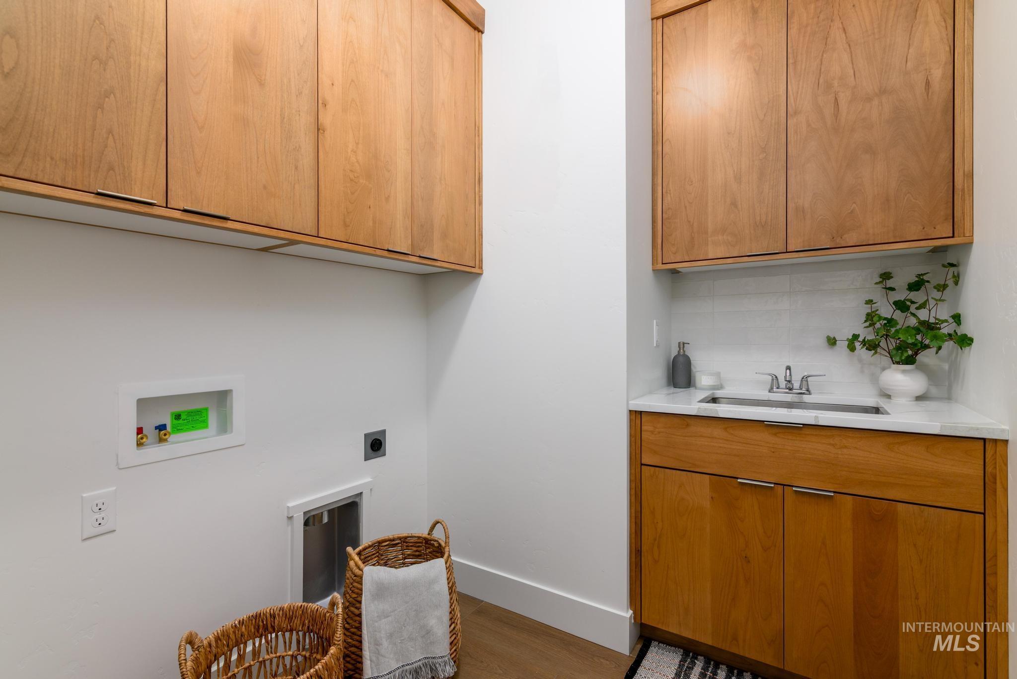 Washroom featuring cabinet space, washer hookup, dark wood finished floors, and hookup for an electric dryer