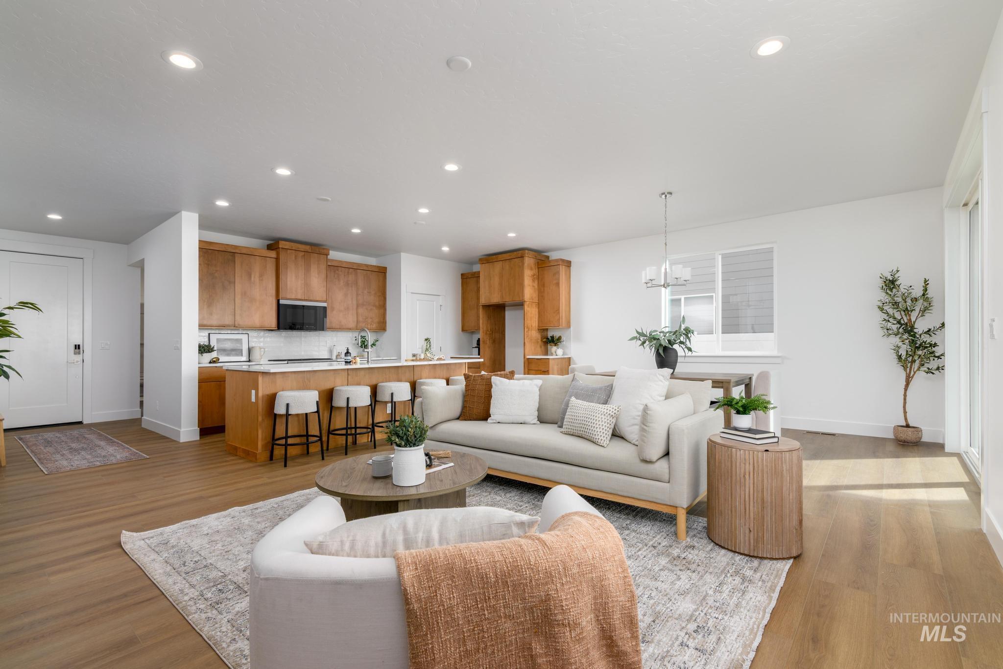 Living room featuring light wood finished floors, recessed lighting, and a chandelier
