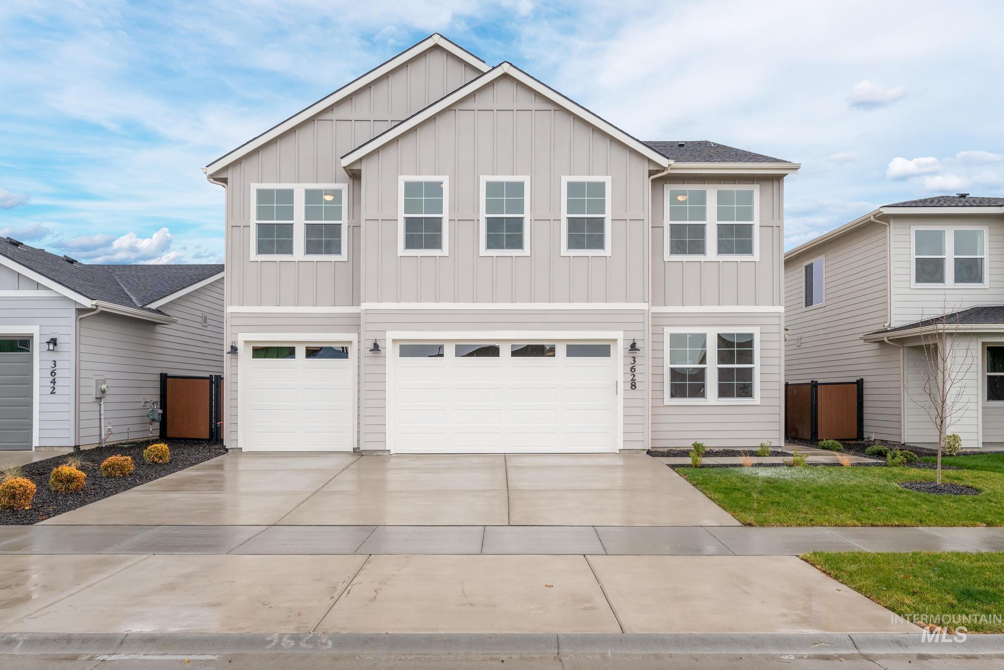 View of front of home featuring board and batten siding, an attached garage, and driveway