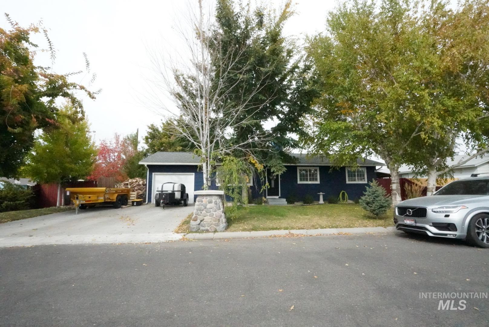 Single story home featuring a front lawn, driveway, and an attached garage