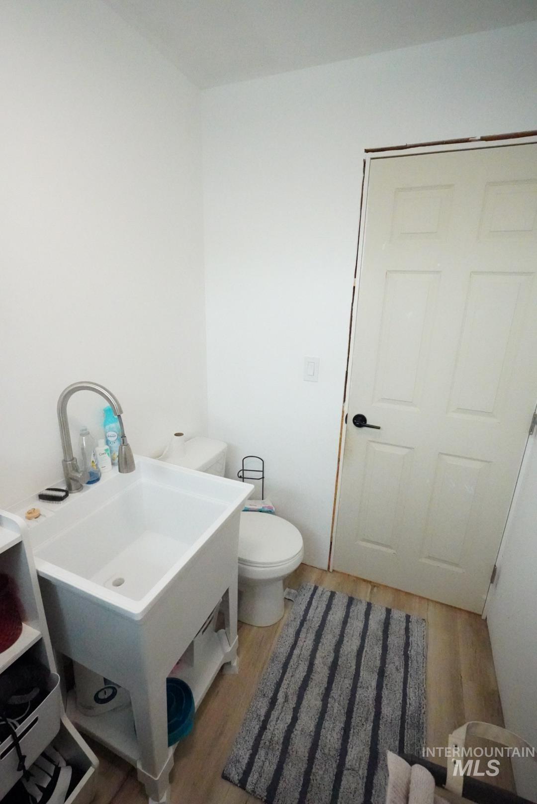 Half bath featuring light wood-type flooring and toilet
