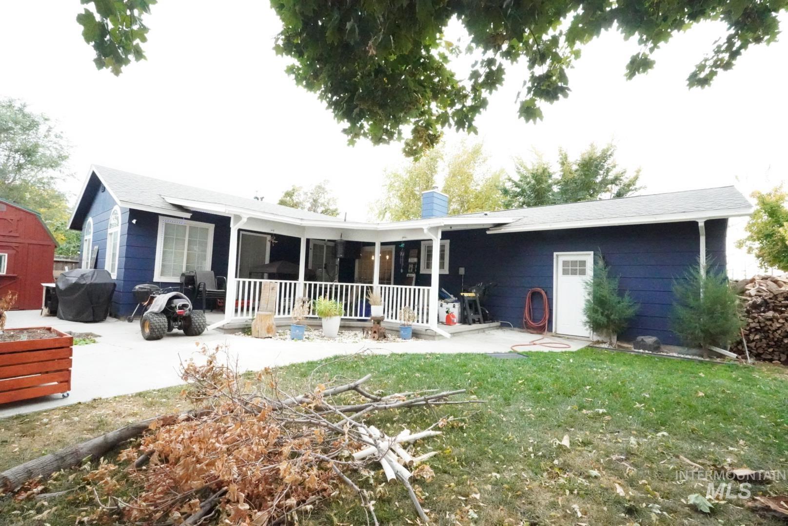 Back of house featuring a patio, a chimney, and a lawn