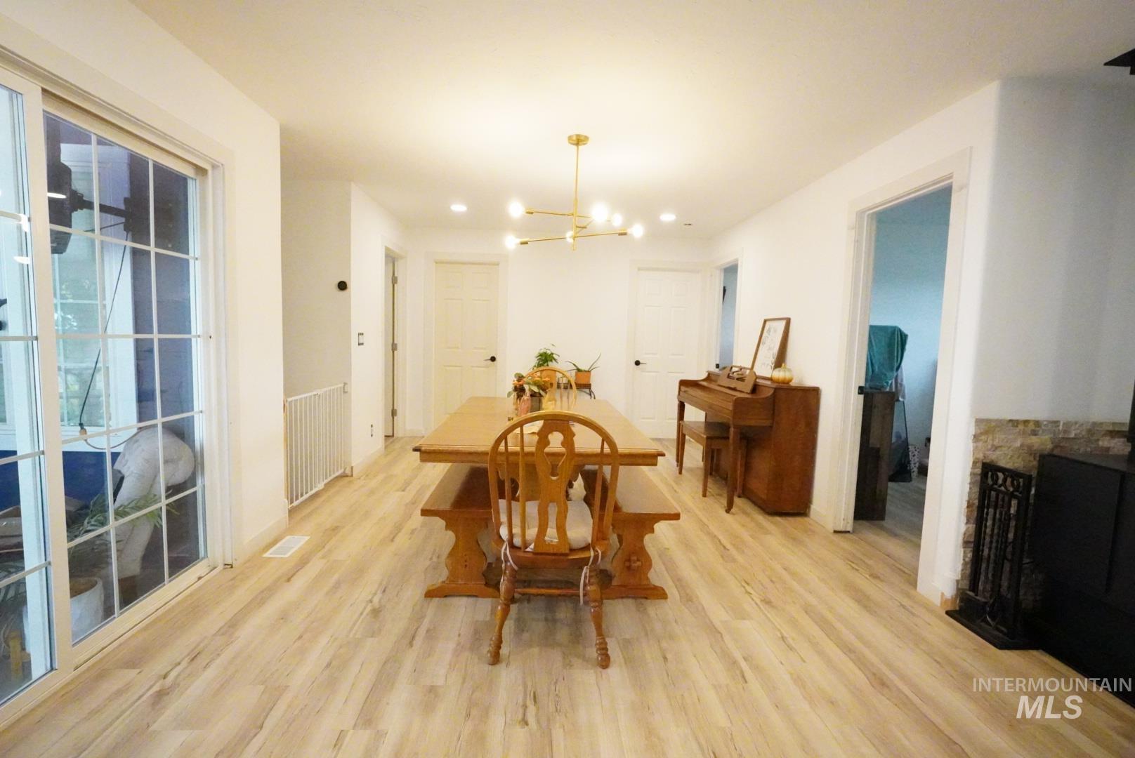 Dining space featuring a chandelier, light wood finished floors, radiator heating unit, and recessed lighting