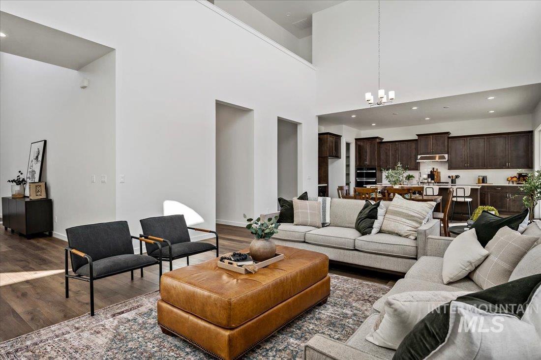 Living area with wood finished floors, recessed lighting, a high ceiling, and a chandelier