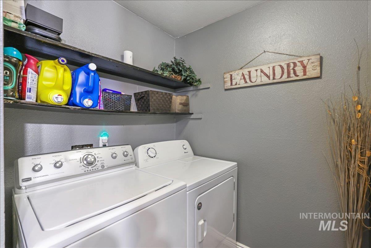 Laundry room with a textured wall and separate washer and dryer