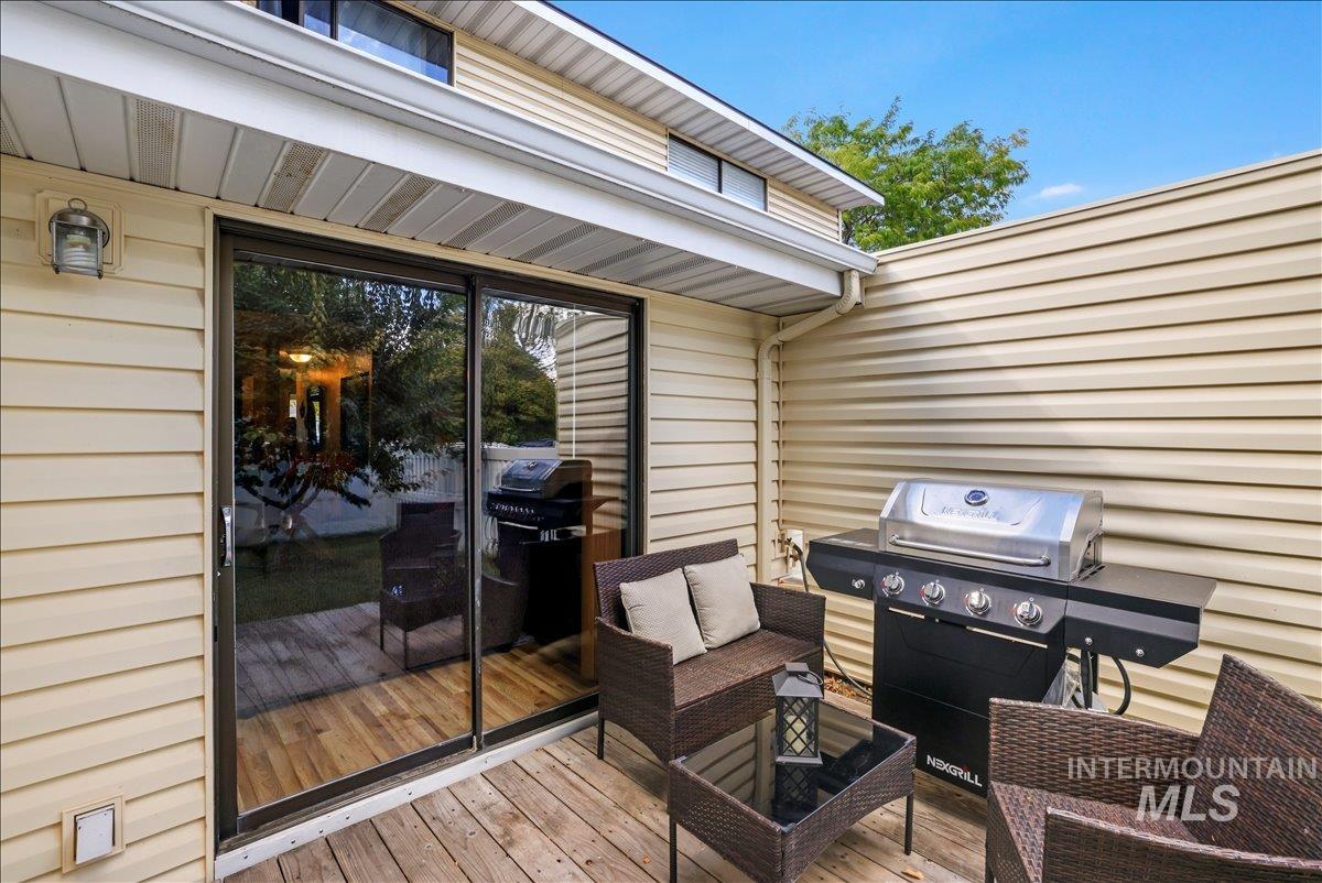 Wooden terrace with area for grilling and outdoor lounge area