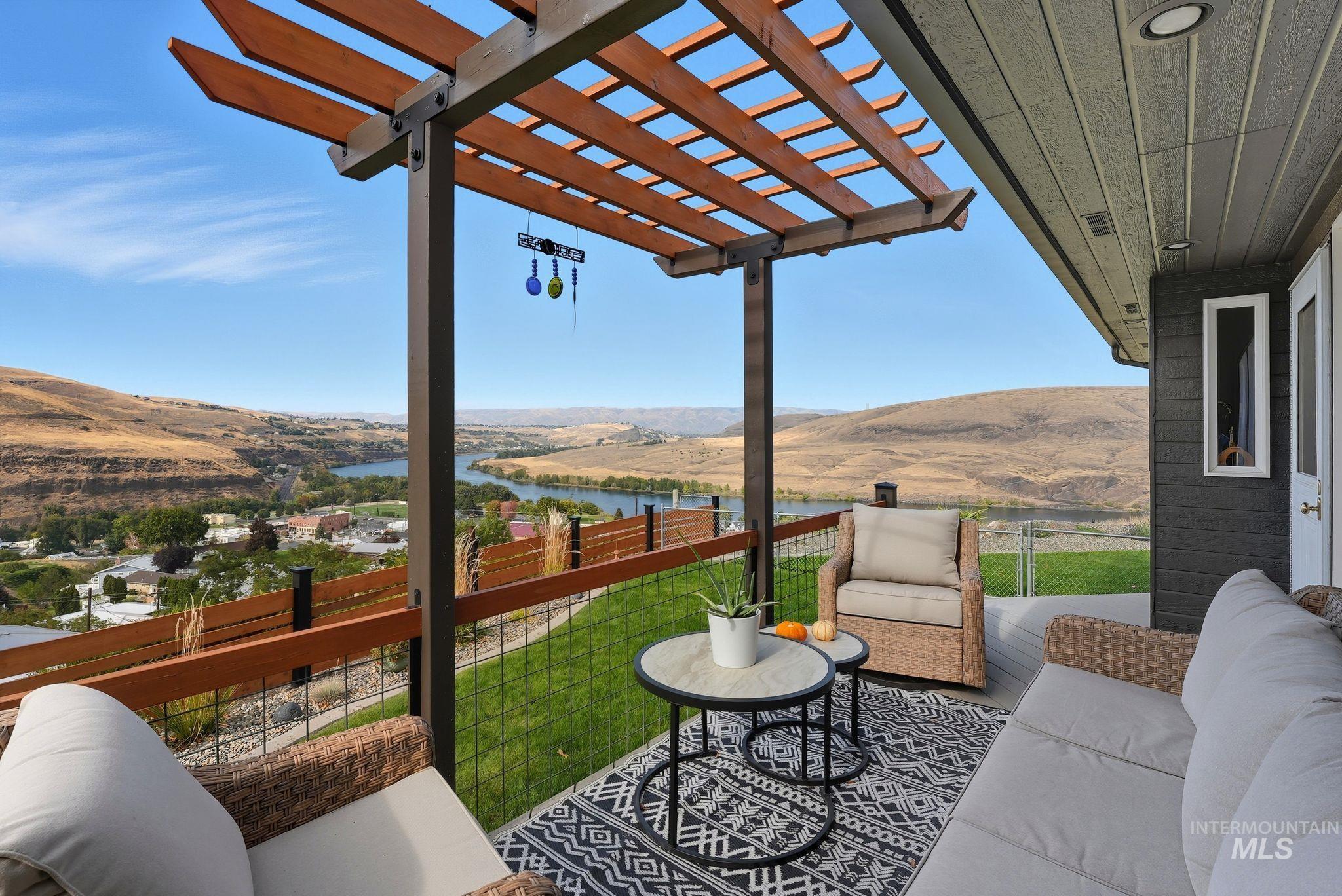 View of patio / terrace with a pergola, an outdoor living space, and a water and mountain view