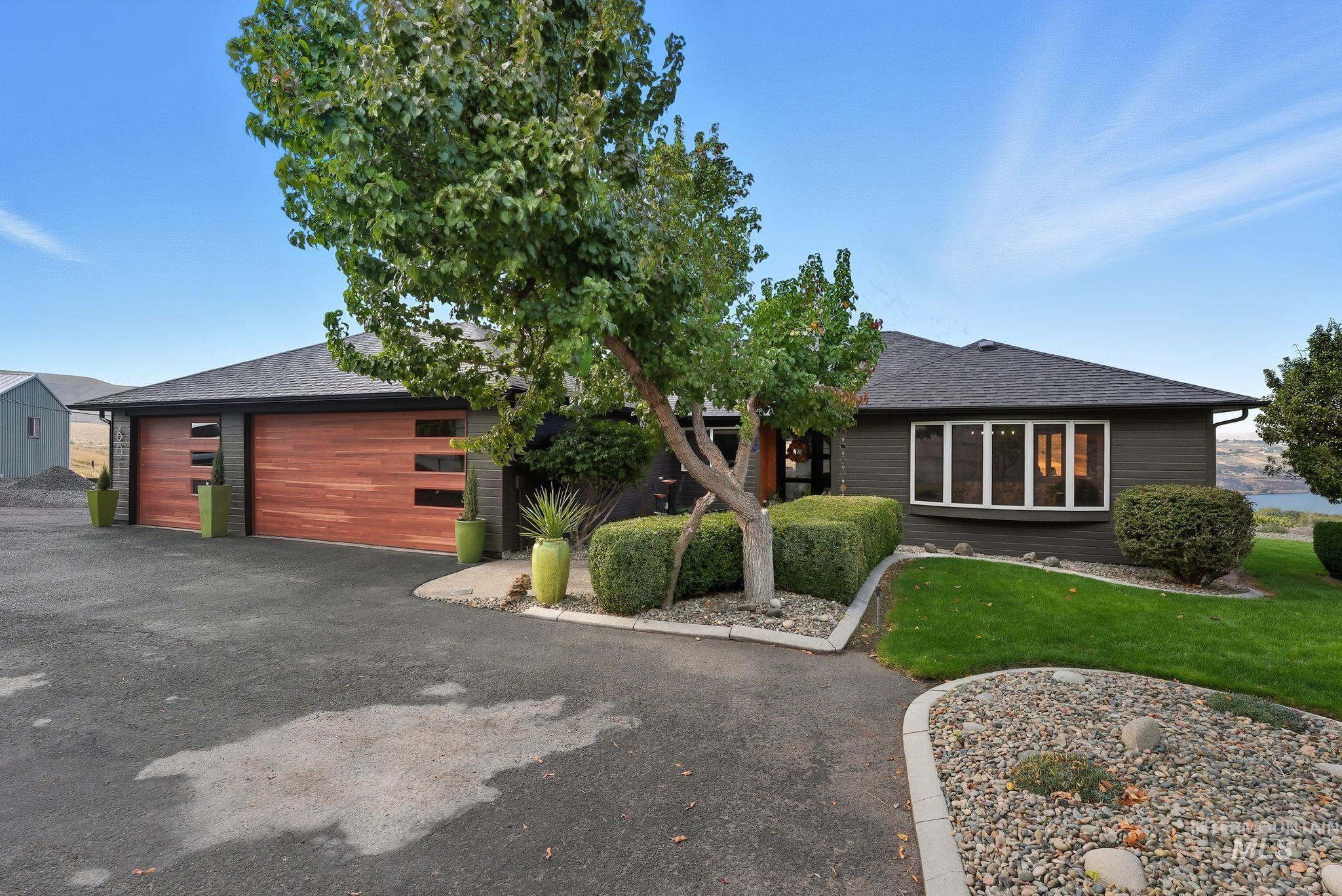 View of front of house with a shingled roof, a garage, and a front yard