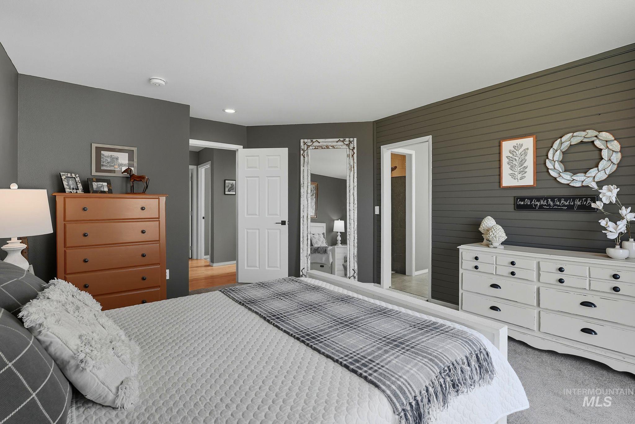 Bedroom featuring light colored carpet and wooden walls