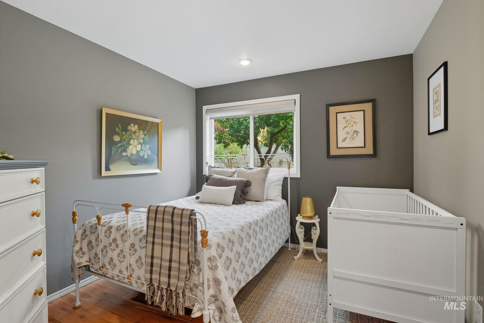 Bedroom with dark wood-style floors and baseboards