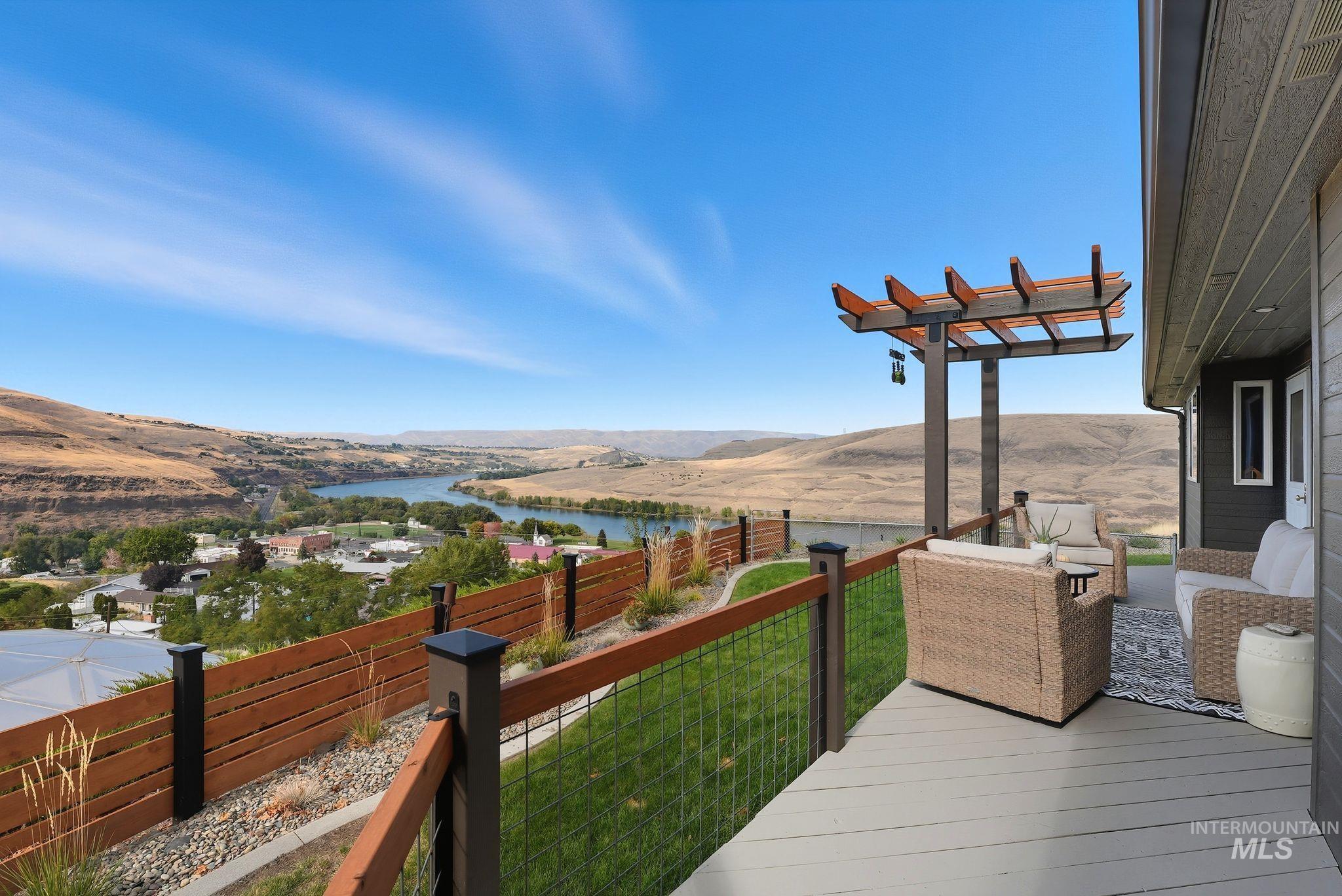 Deck with a fenced backyard and a water and mountain view