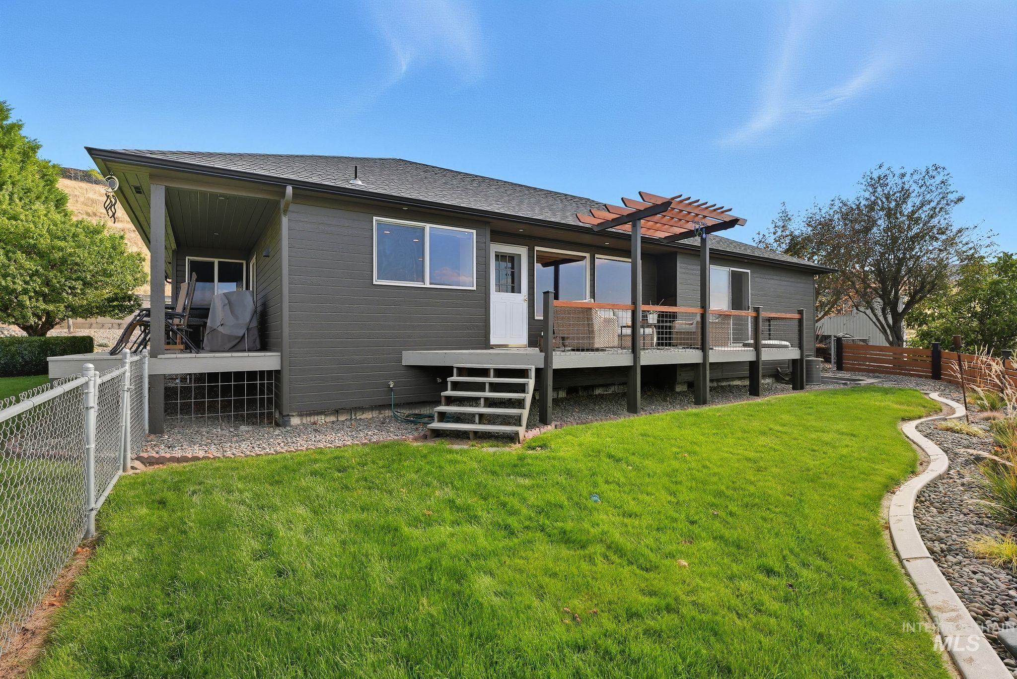 Rear view of house with a fenced backyard, a deck, and a shingled roof