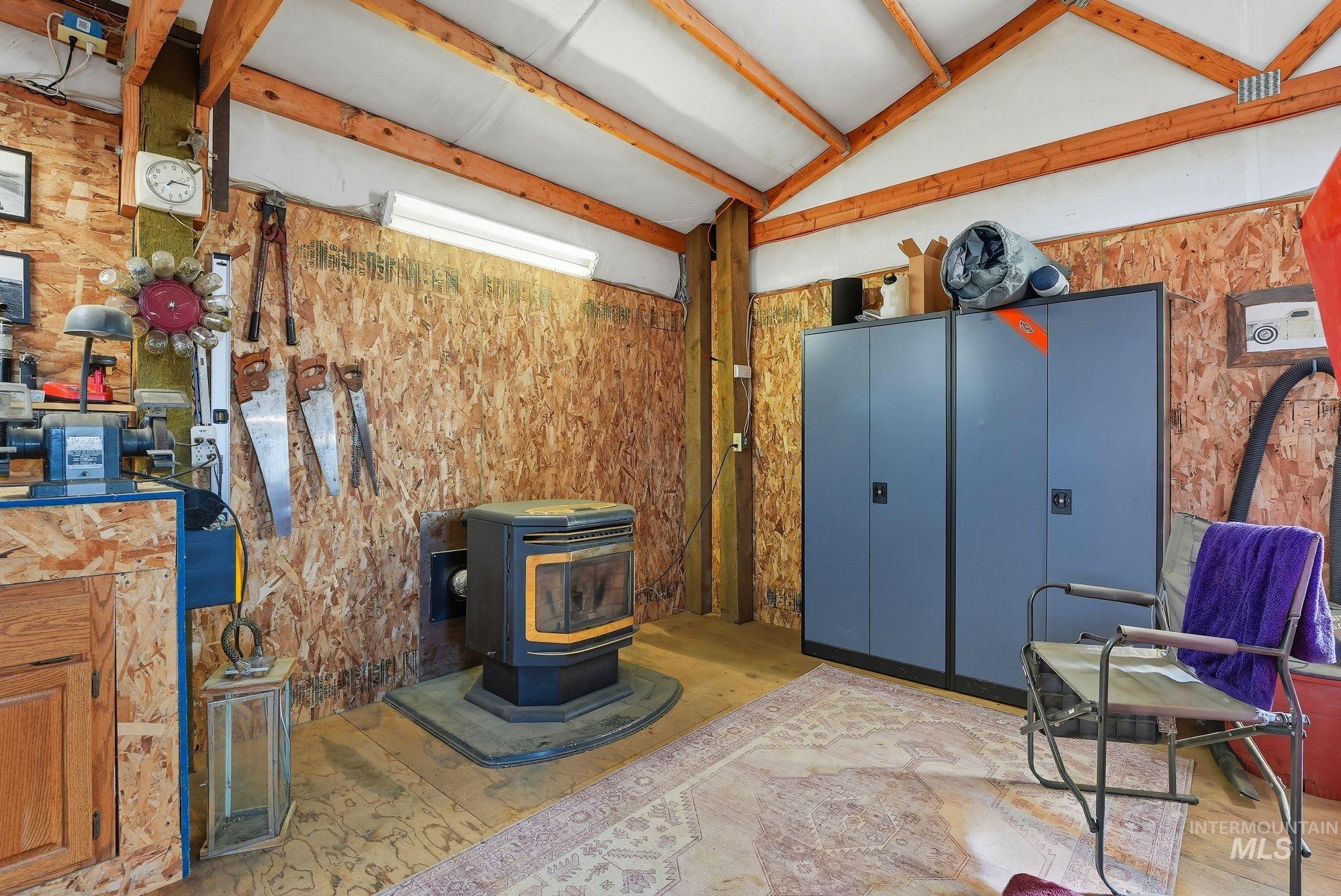 Misc room featuring a wood stove and lofted ceiling