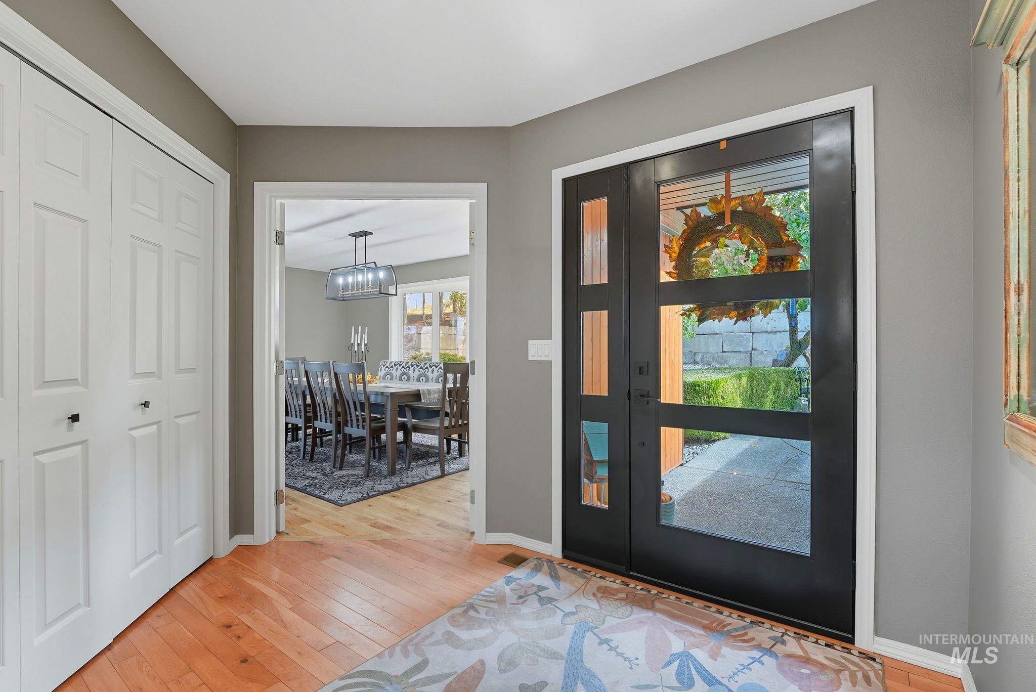 Foyer entrance with light wood finished floors and baseboards