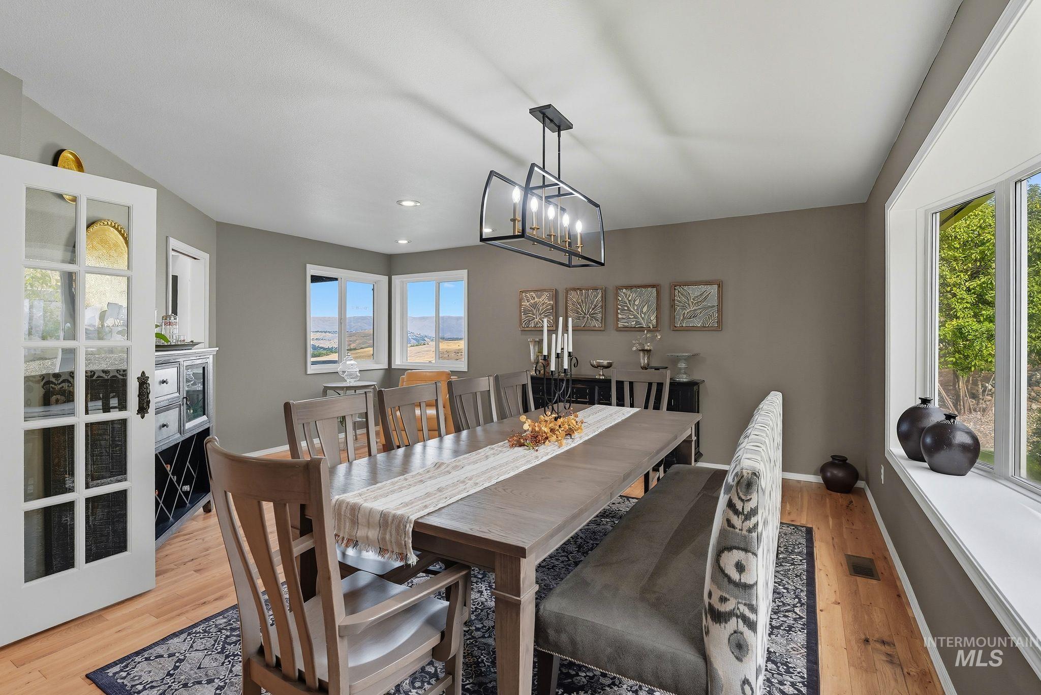 Dining room with light wood-style flooring and recessed lighting