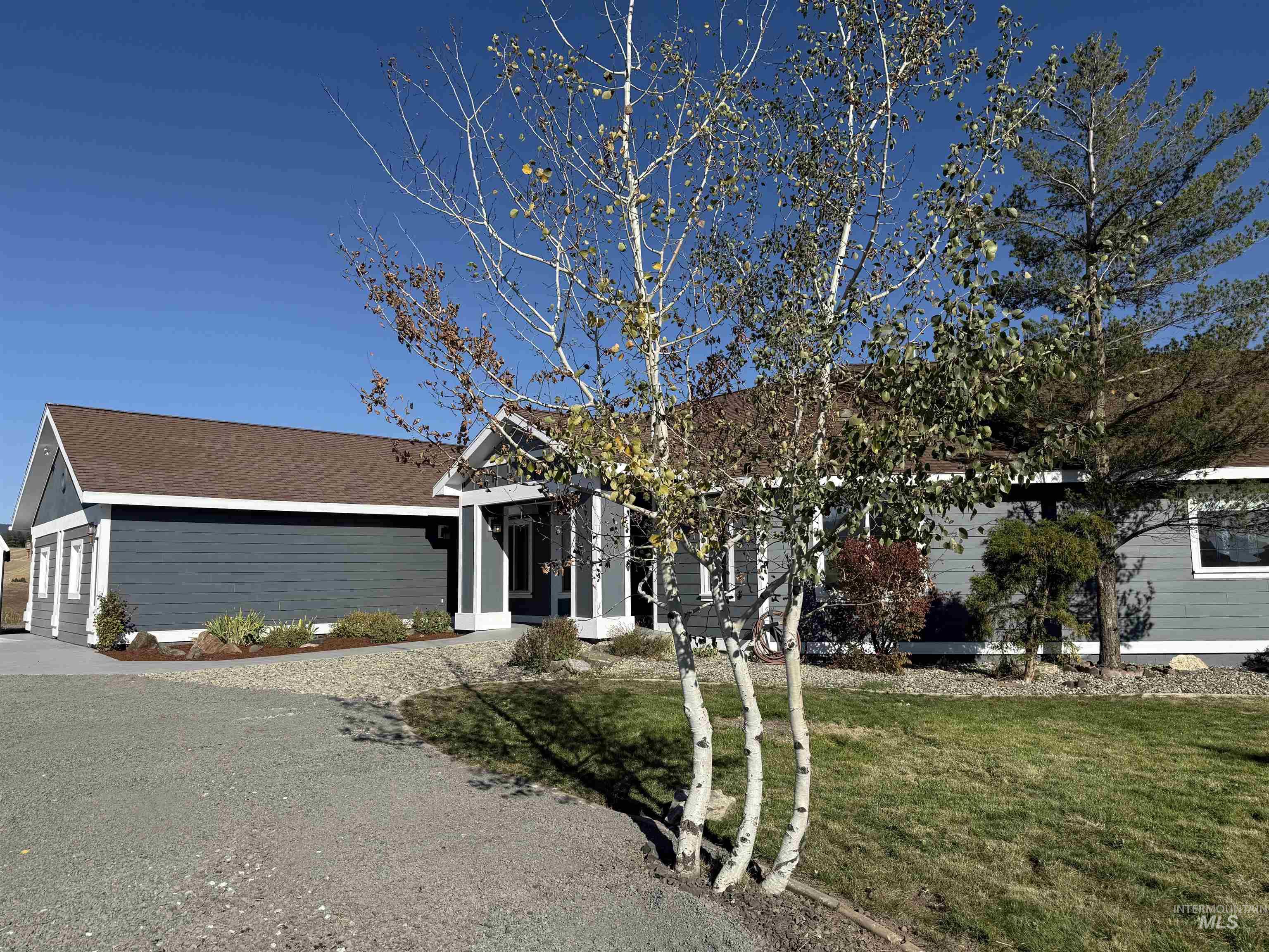 Ranch-style house with a front yard, a garage, and driveway