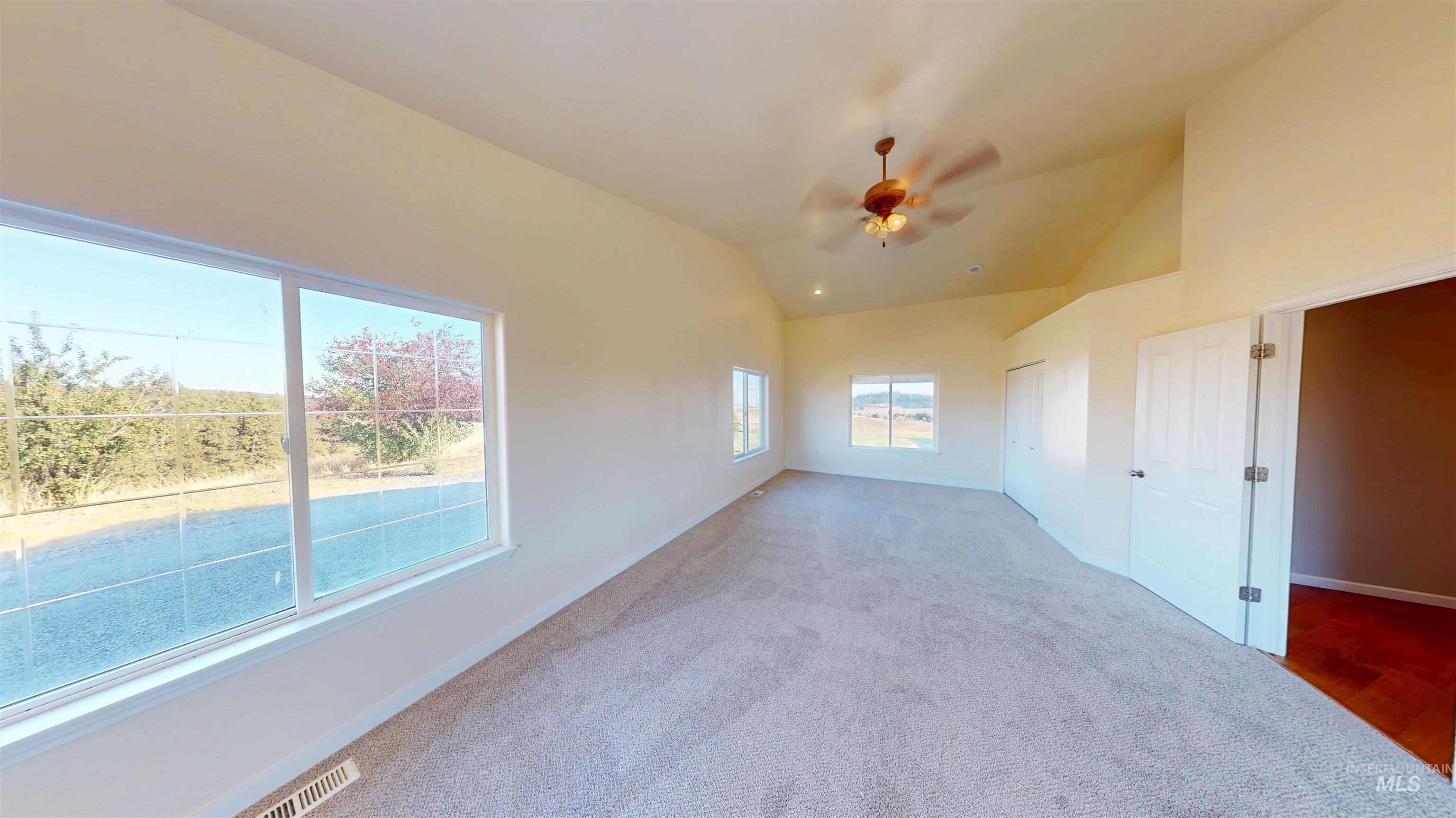 Unfurnished bedroom with lofted ceiling, carpet floors, ceiling fan, and a closet