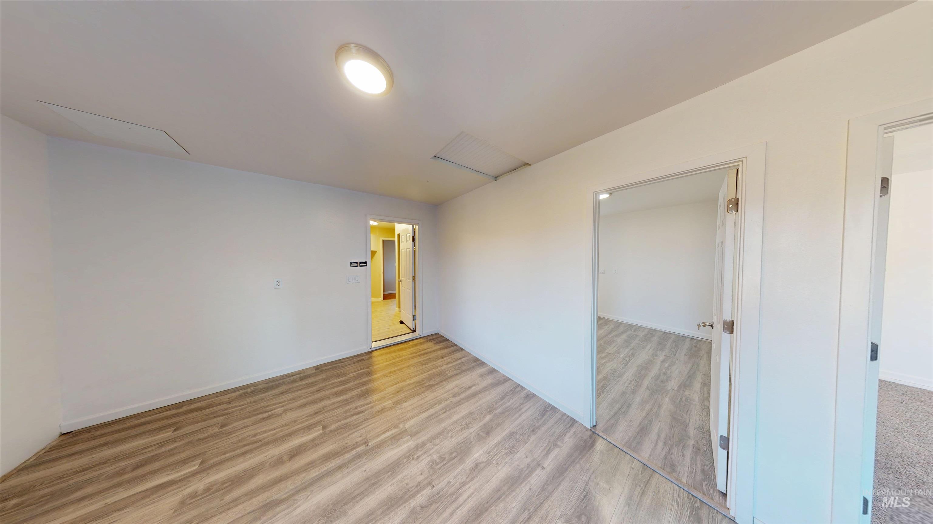 Unfurnished room with light wood-type flooring and baseboards