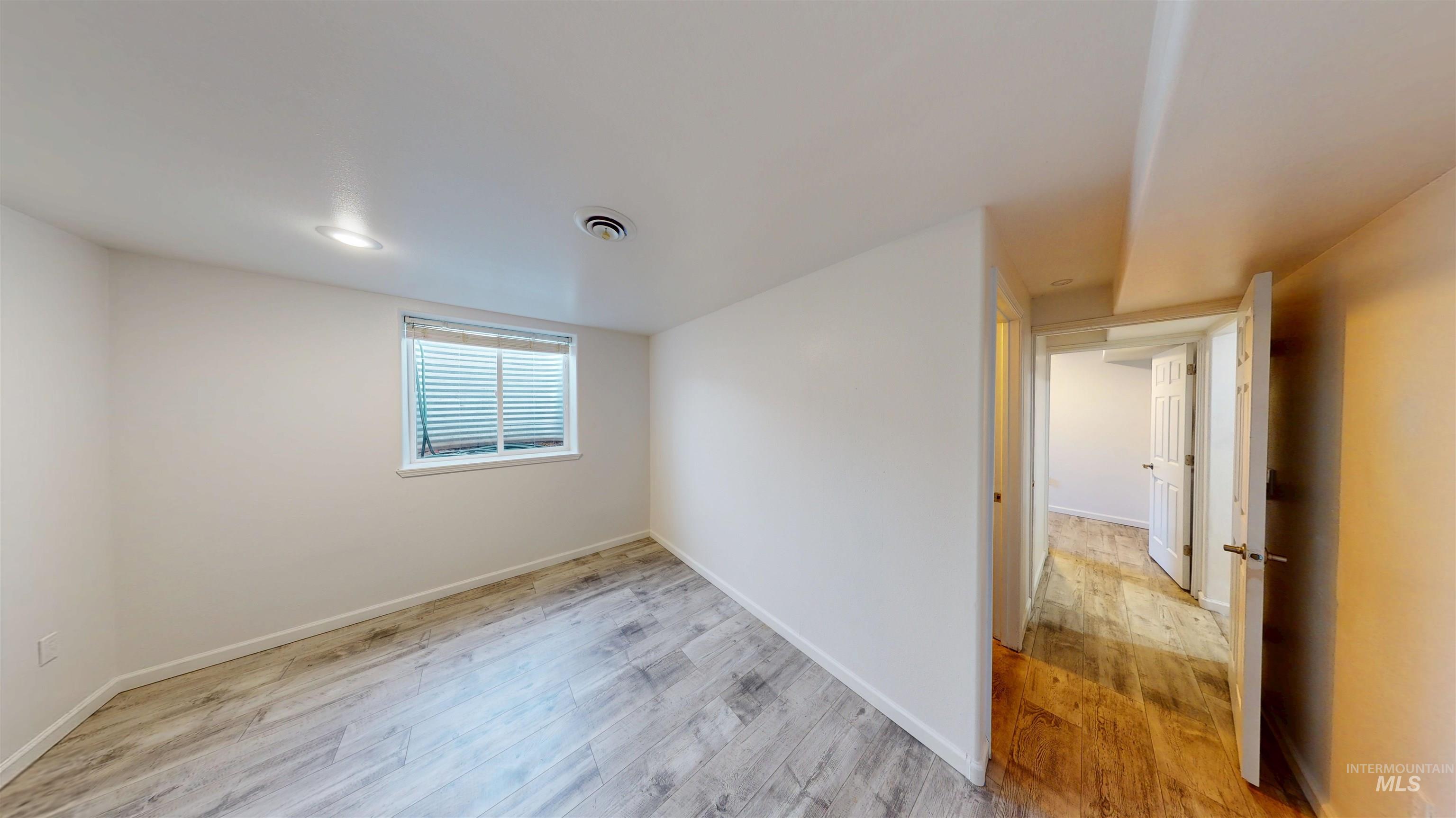 Unfurnished room featuring light wood-style flooring and baseboards