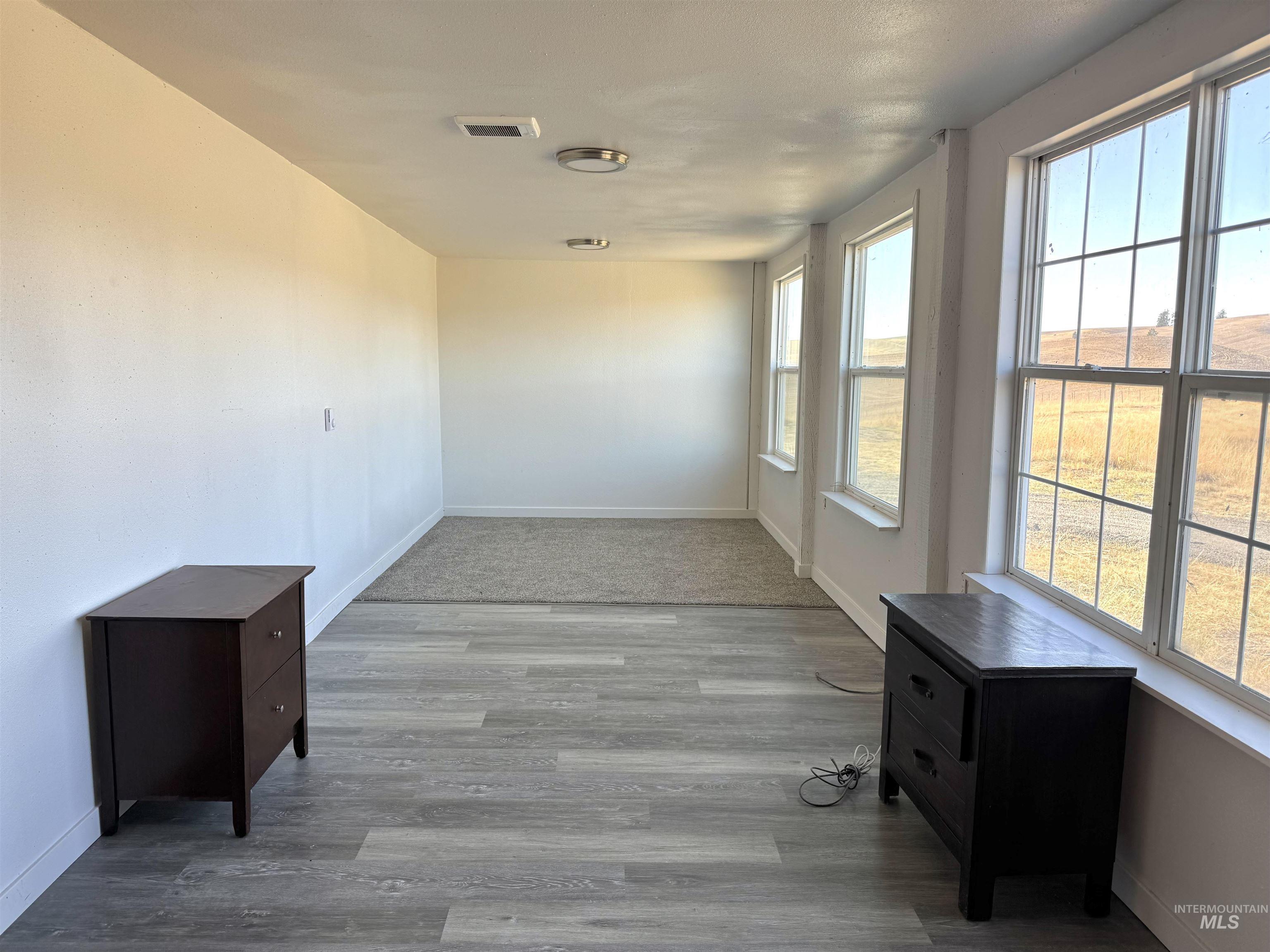 Empty room with baseboards and light wood-style flooring