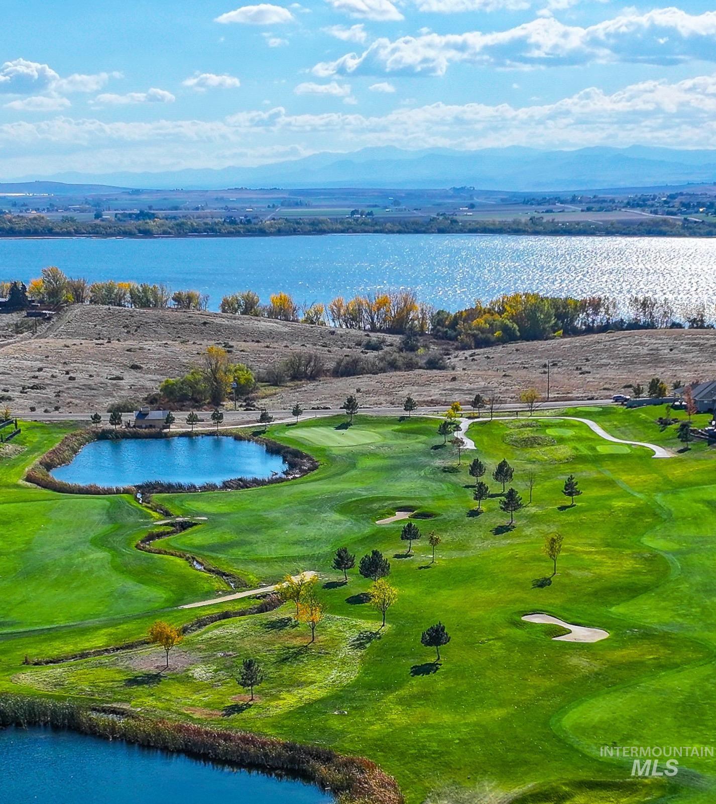 Drone / aerial view of a water and mountain view and a local golf course