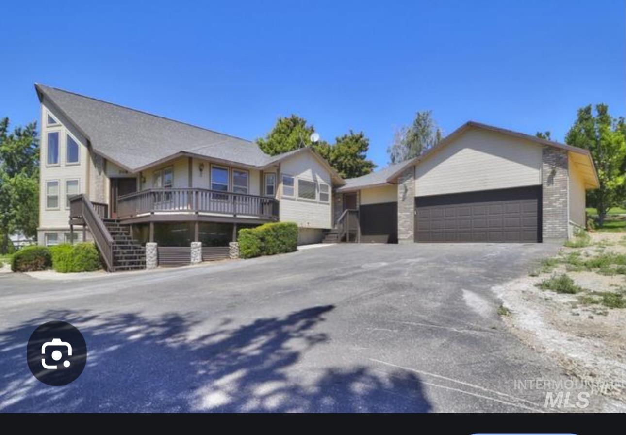 View of front of property featuring an outdoor structure, stairway, driveway, and an attached garage