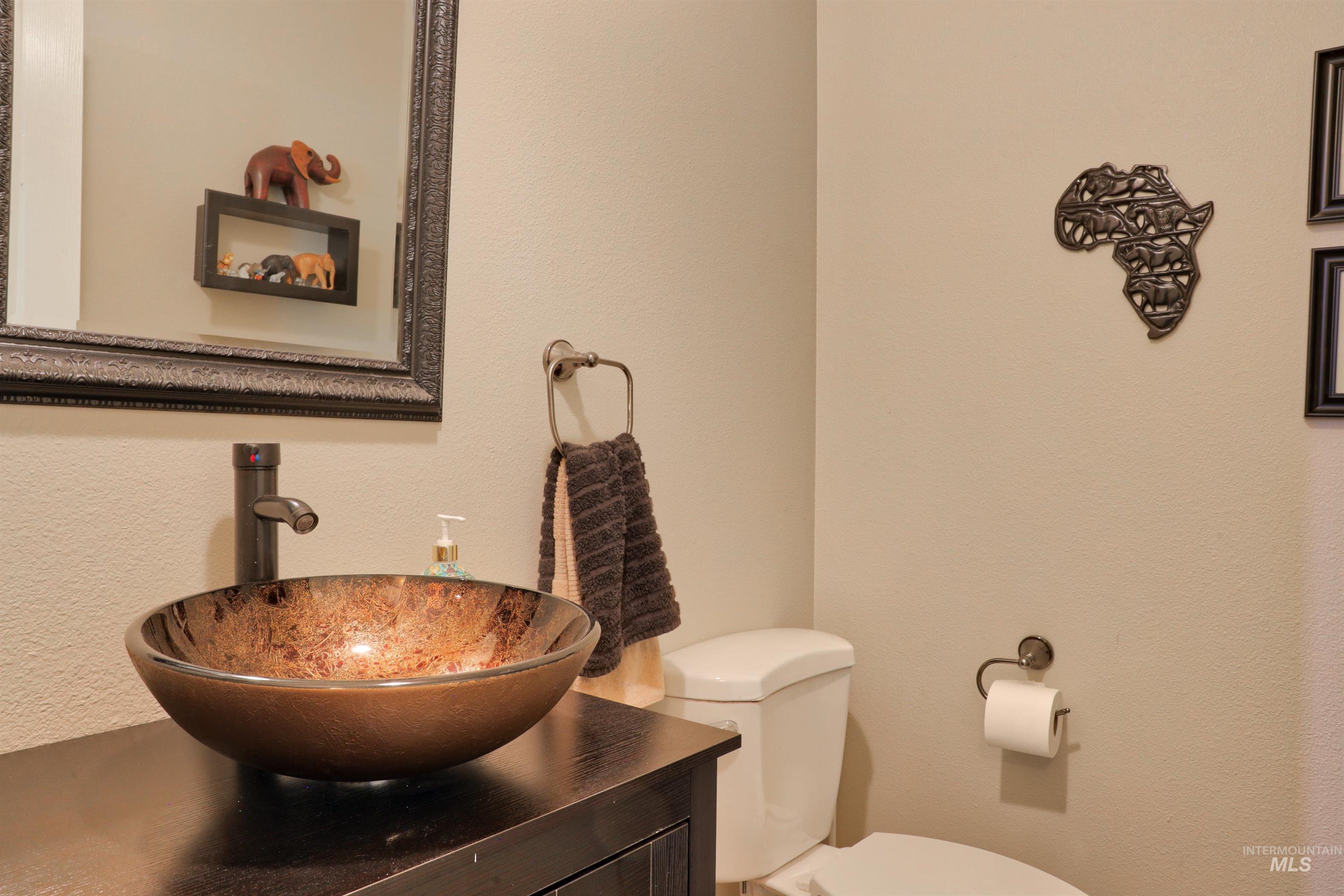 Half bathroom featuring a textured wall and vanity