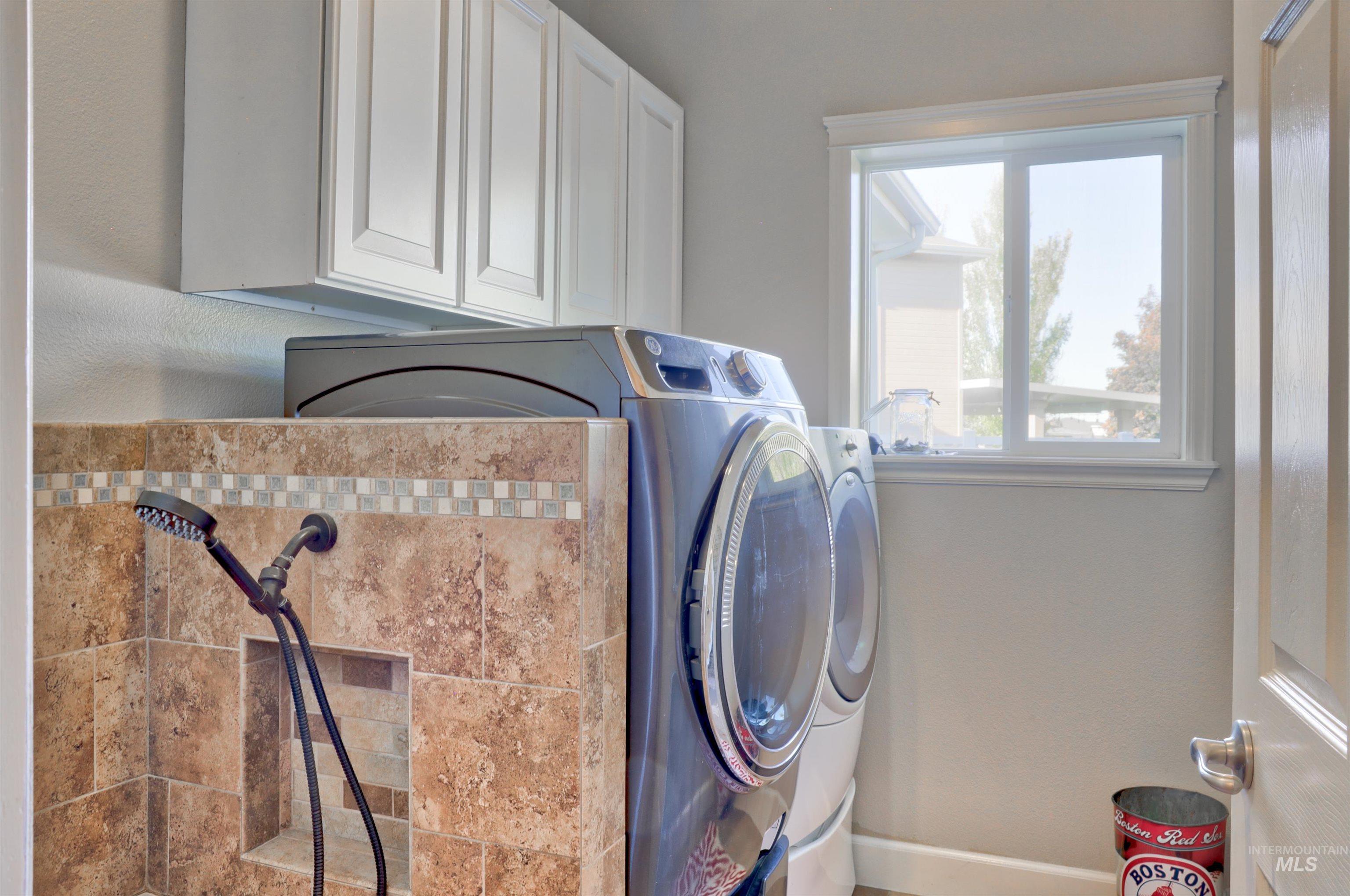 Laundry area featuring washing machine and clothes dryer and cabinet space