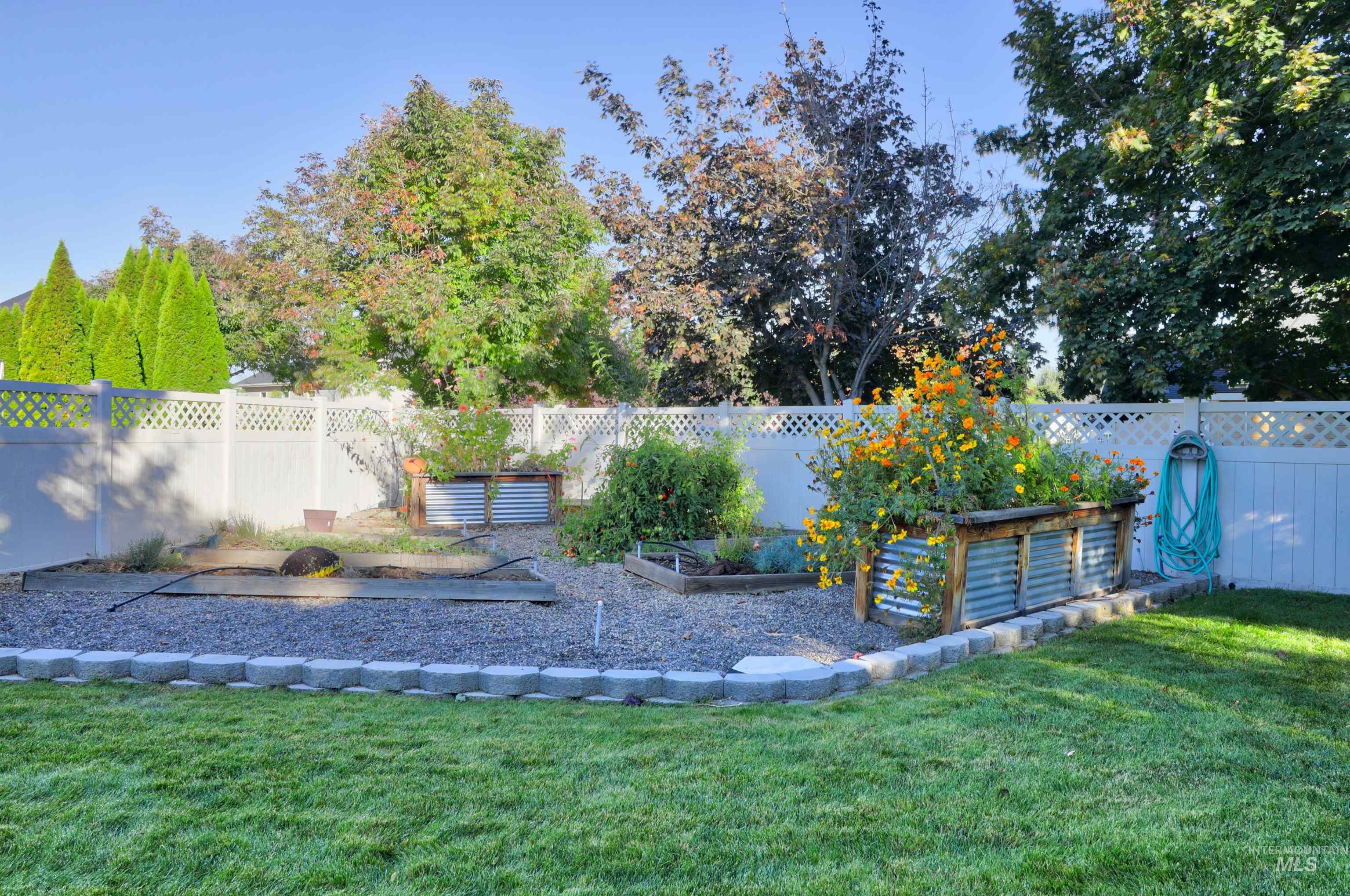 Fenced backyard featuring a vegetable garden