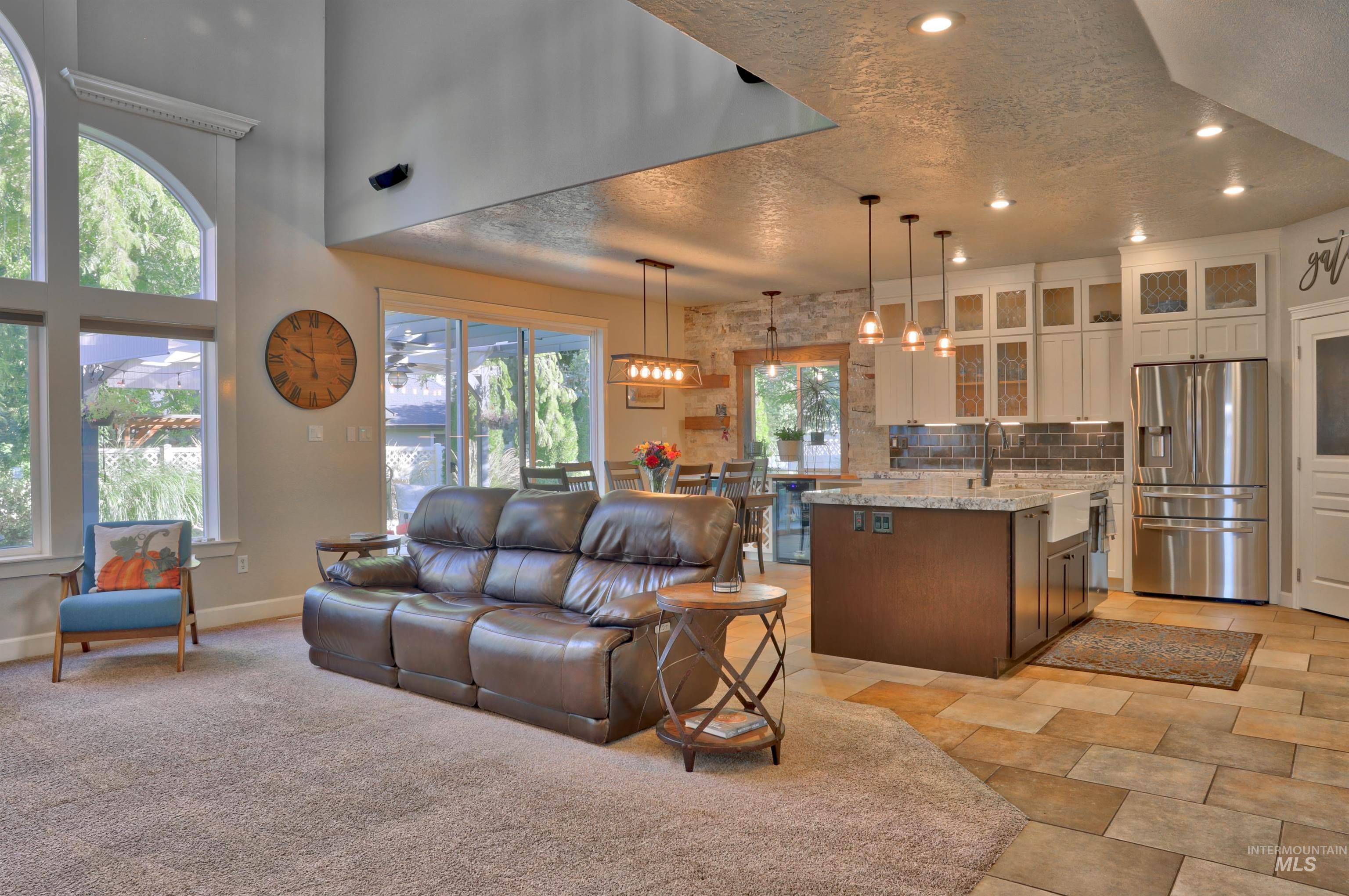 Living room featuring a textured ceiling, recessed lighting, and a high ceiling