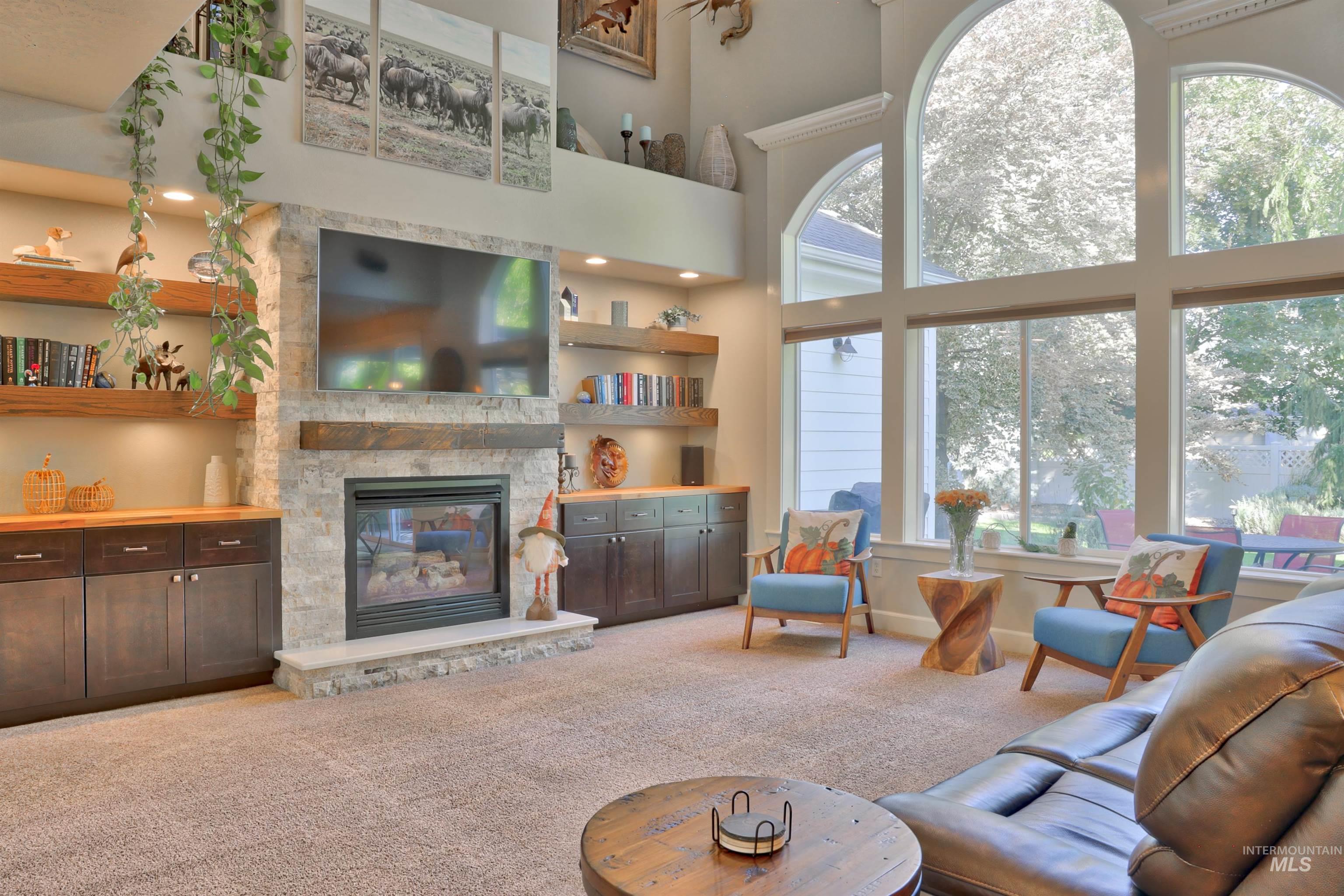 Living room featuring light carpet, a fireplace, and a high ceiling
