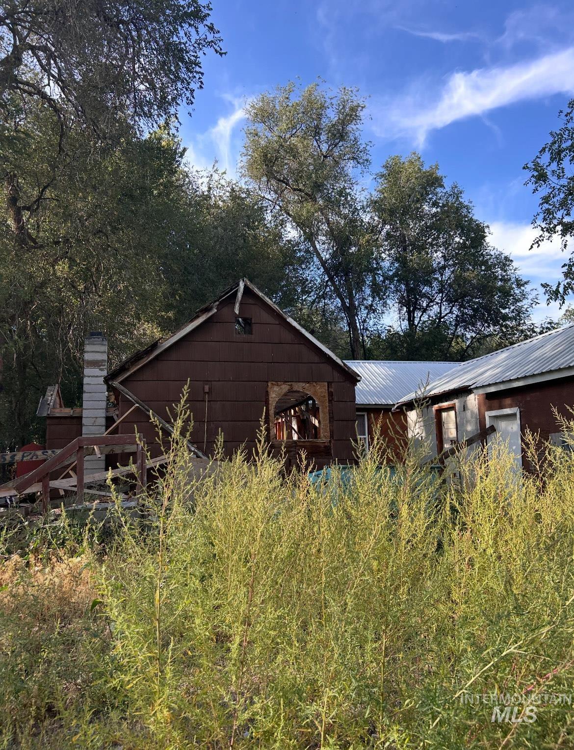 View of home's exterior featuring a metal roof and a chimney