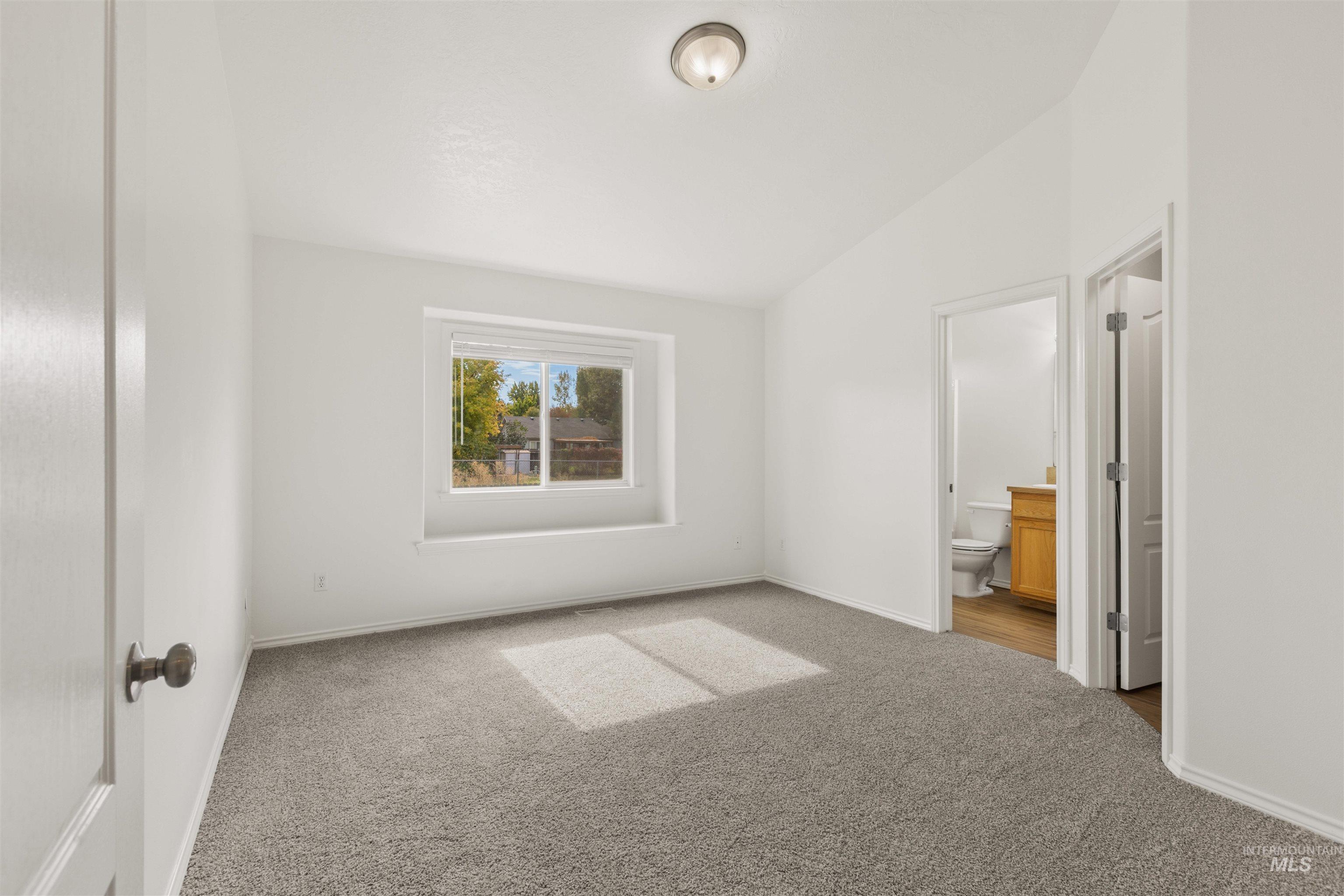 Unfurnished bedroom featuring carpet flooring and ensuite bathroom
