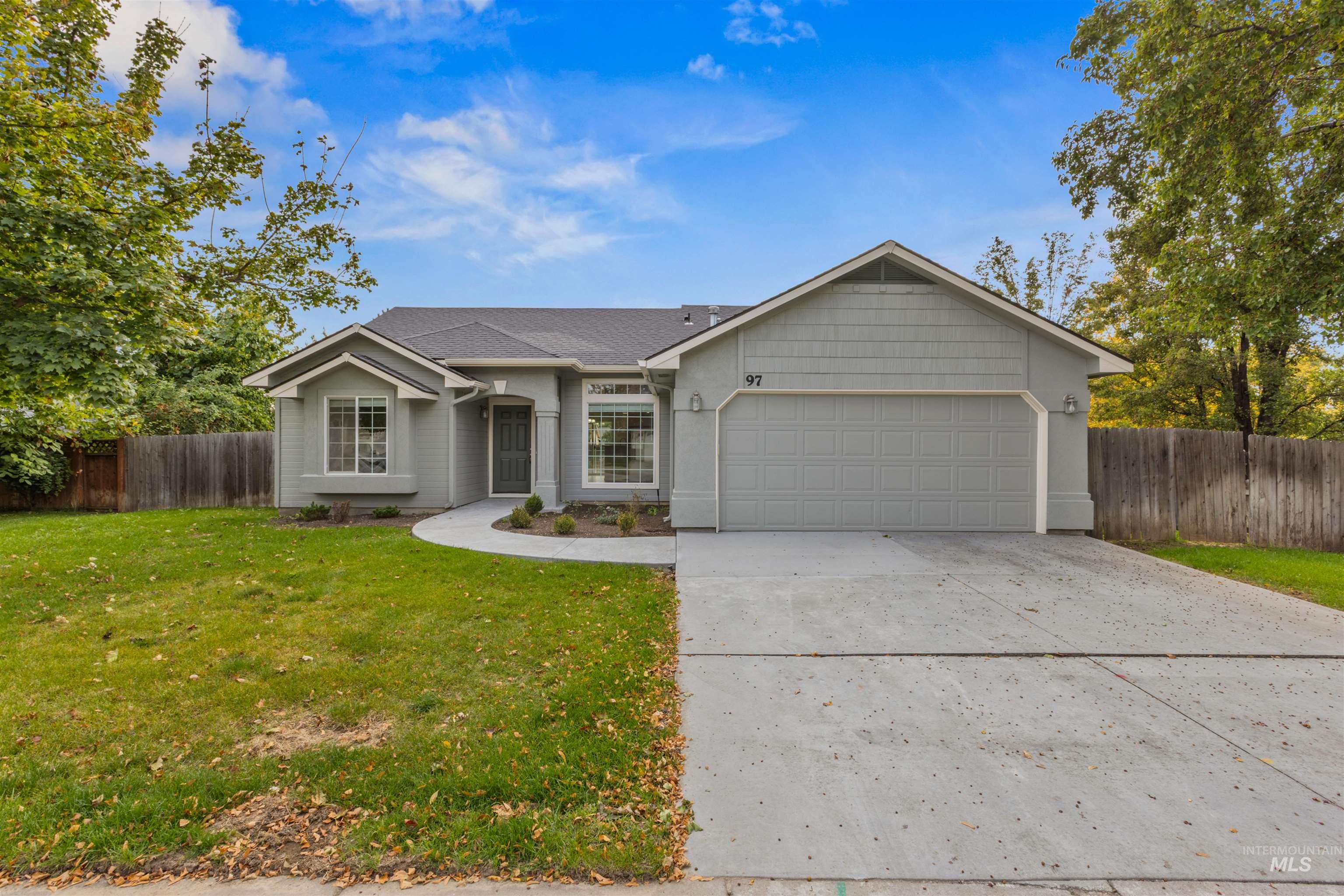 Ranch-style home with concrete driveway, an attached garage, and a shingled roof
