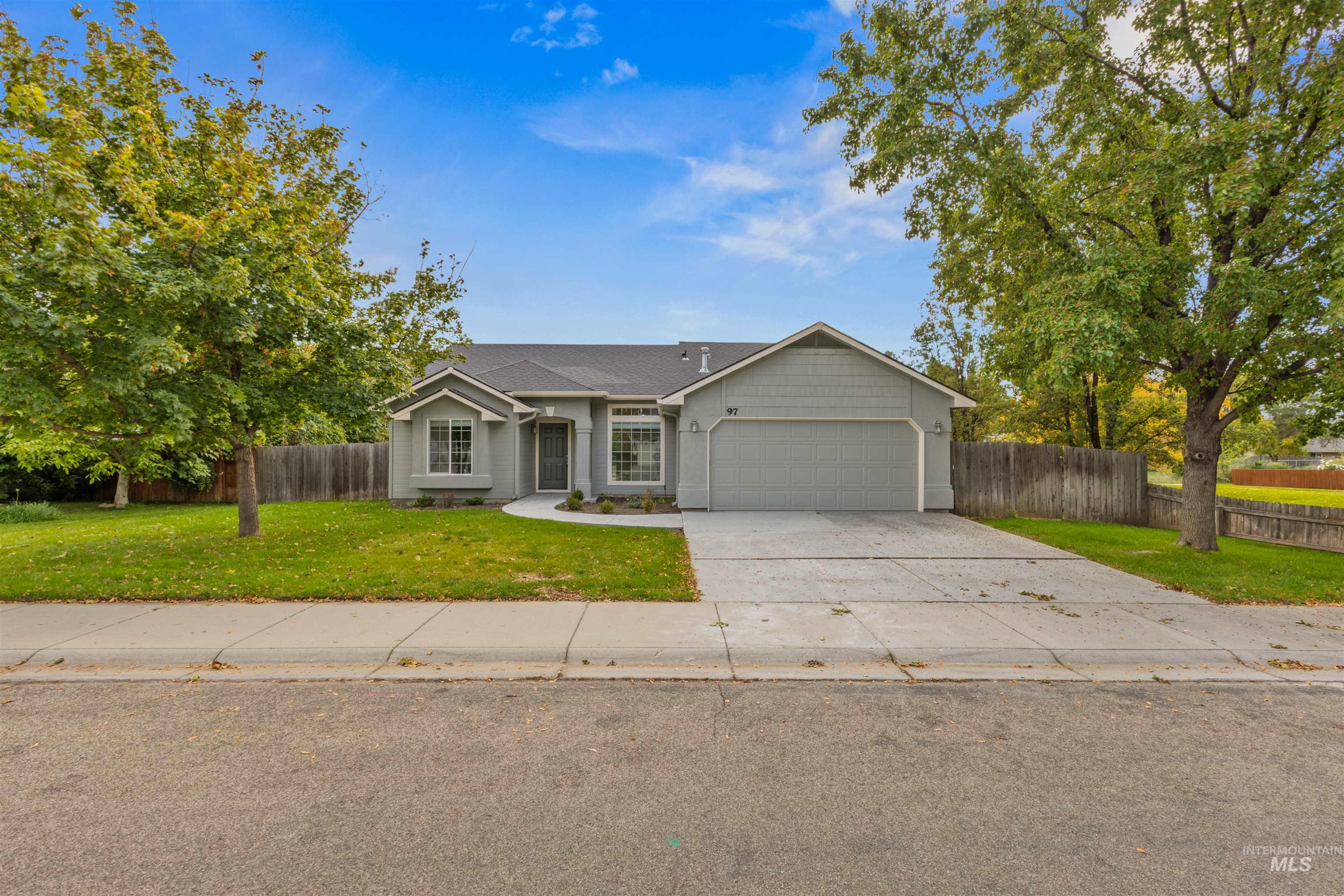 Single story home featuring concrete driveway and an attached garage