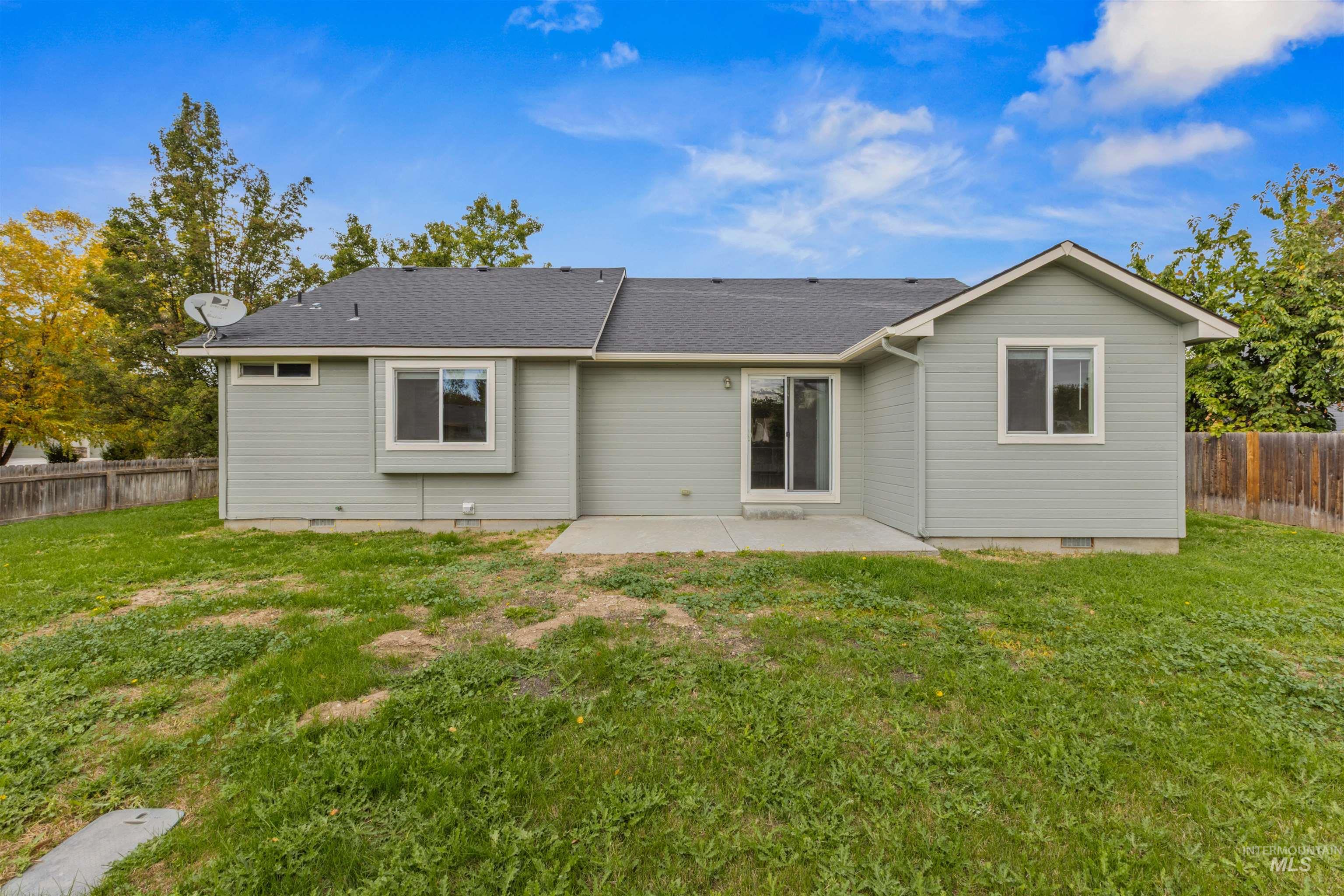 Back of property with a fenced backyard, a patio, a shingled roof, and crawl space