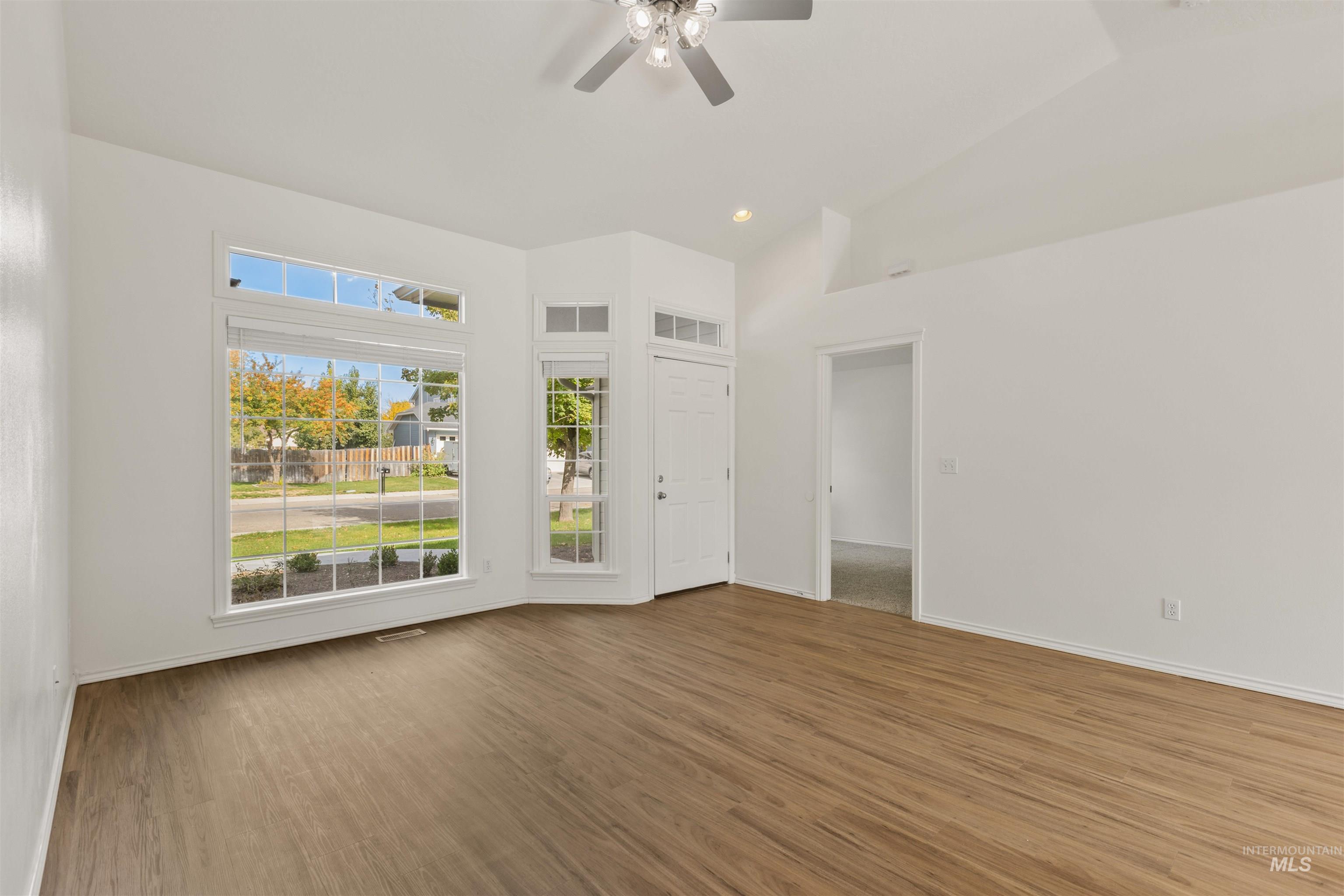 Unfurnished room with wood finished floors, recessed lighting, a ceiling fan, and lofted ceiling