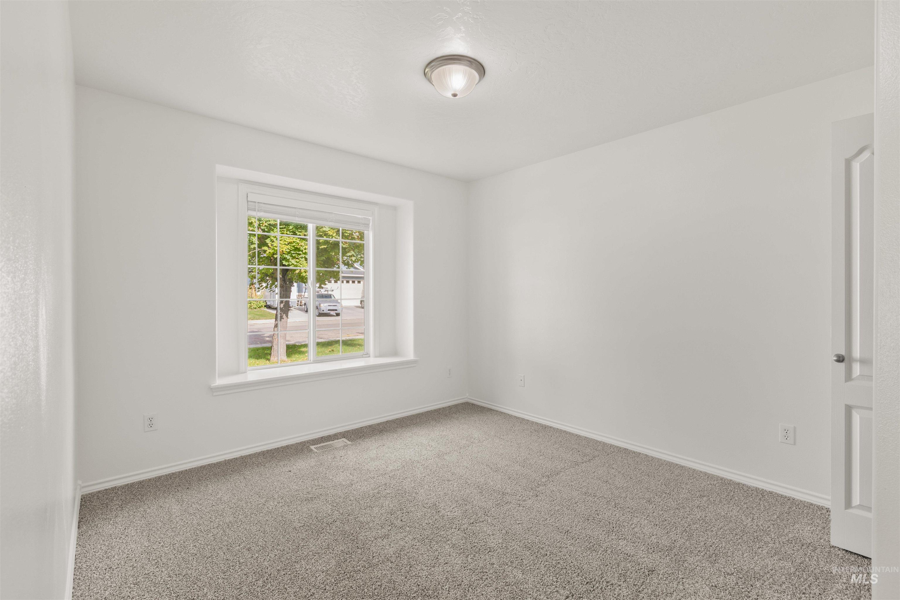 Carpeted empty room featuring baseboards
