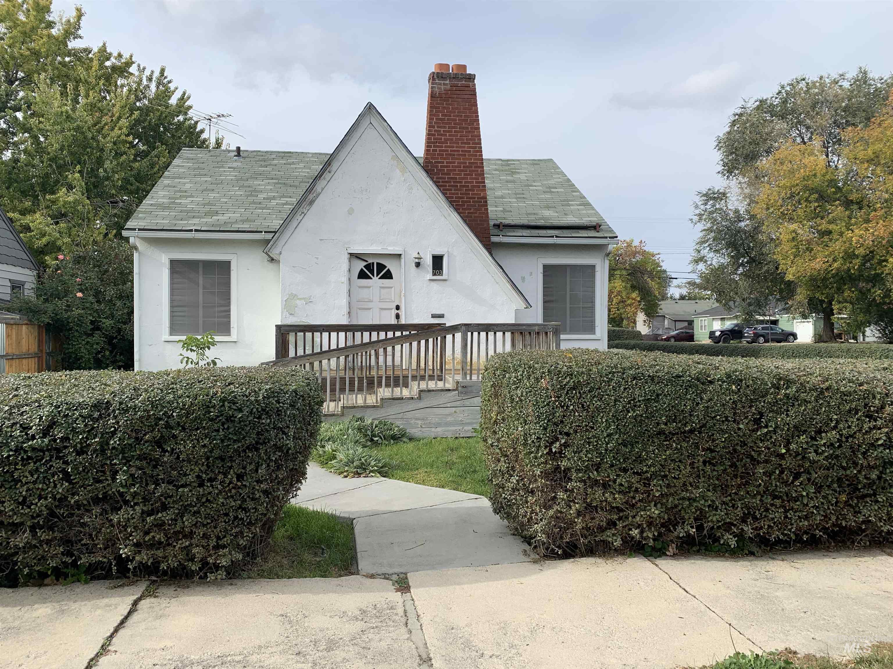 View of home's exterior with stucco siding, a chimney, and a shingled roof