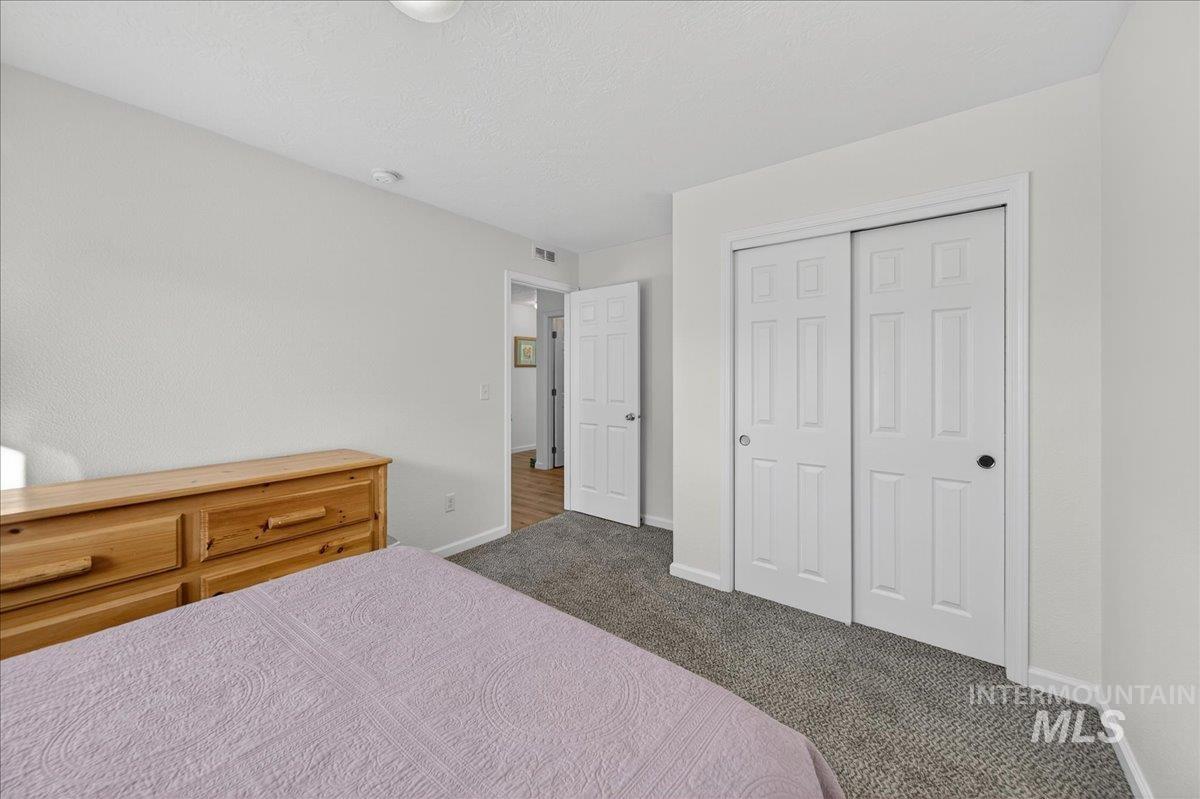 Carpeted bedroom featuring a closet and a textured ceiling