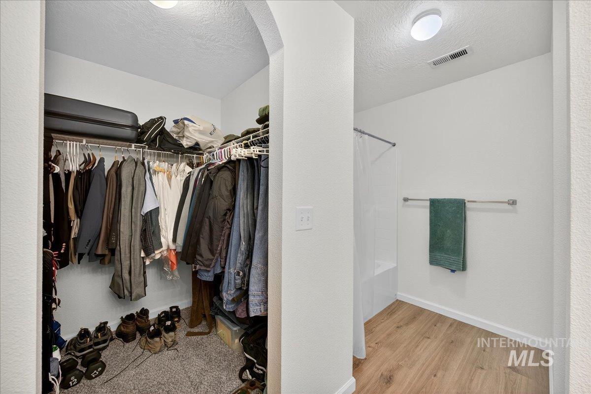 Walk in closet with light wood-style flooring