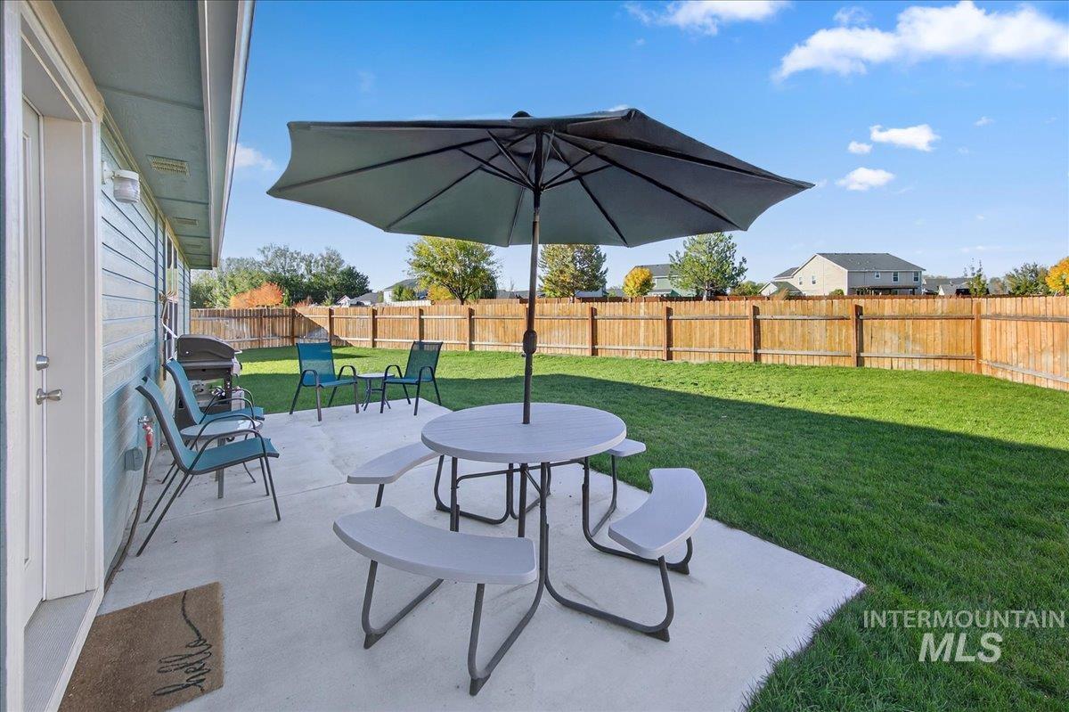 Fenced backyard with a patio and a grill