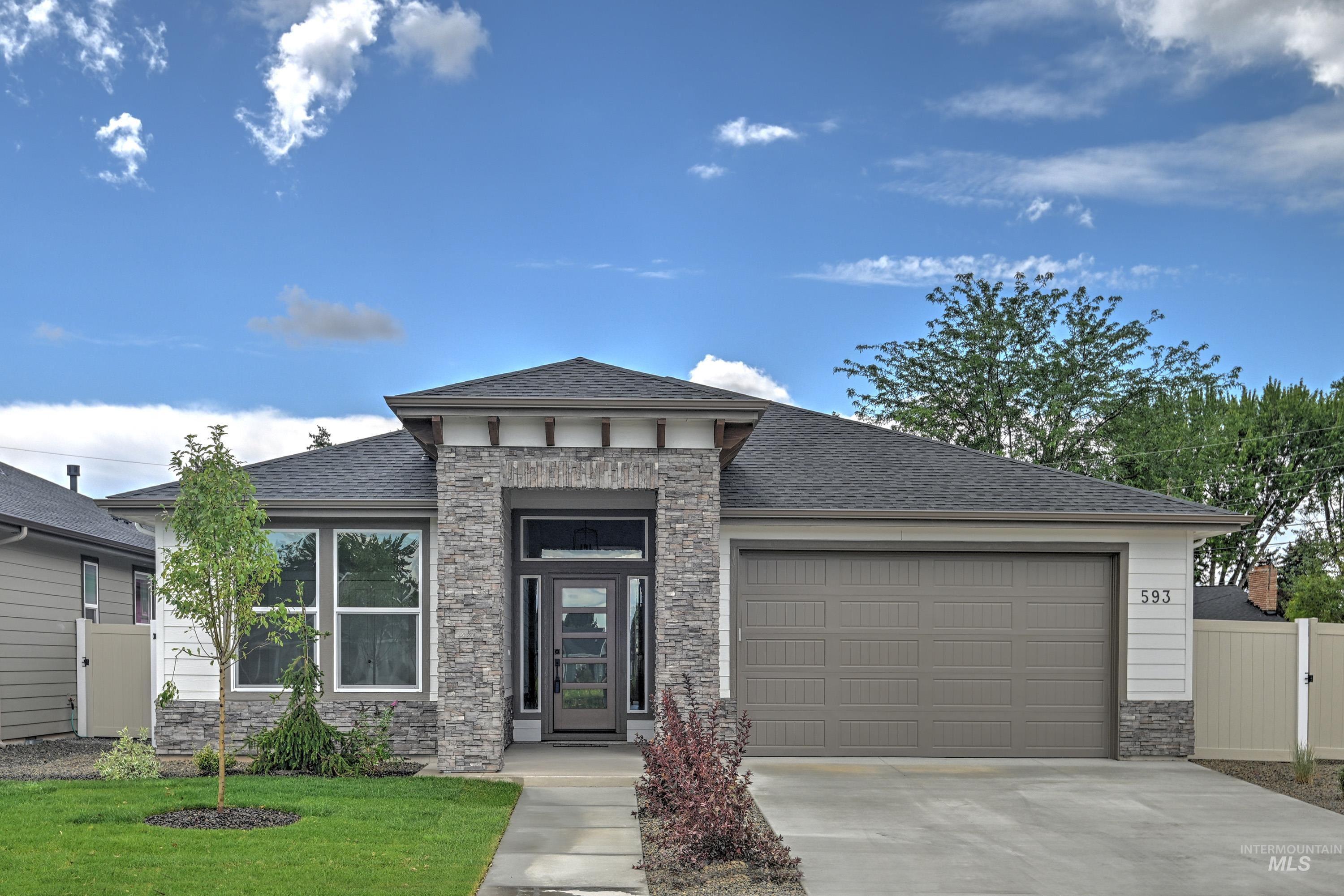 Prairie-style home featuring stone siding, driveway, an attached garage, and a shingled roof