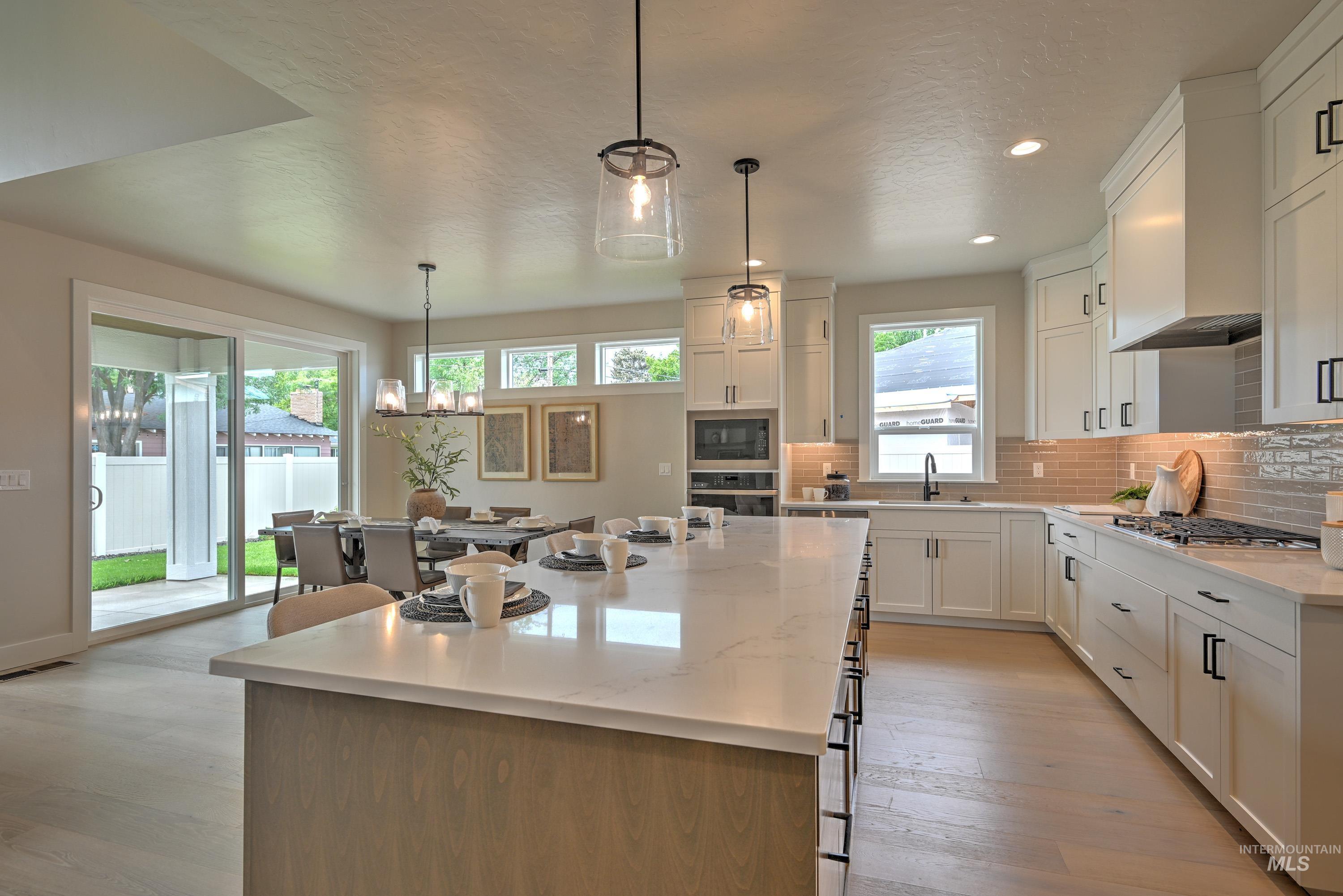 Kitchen with appliances with stainless steel finishes, recessed lighting, decorative backsplash, a kitchen island, and white cabinets