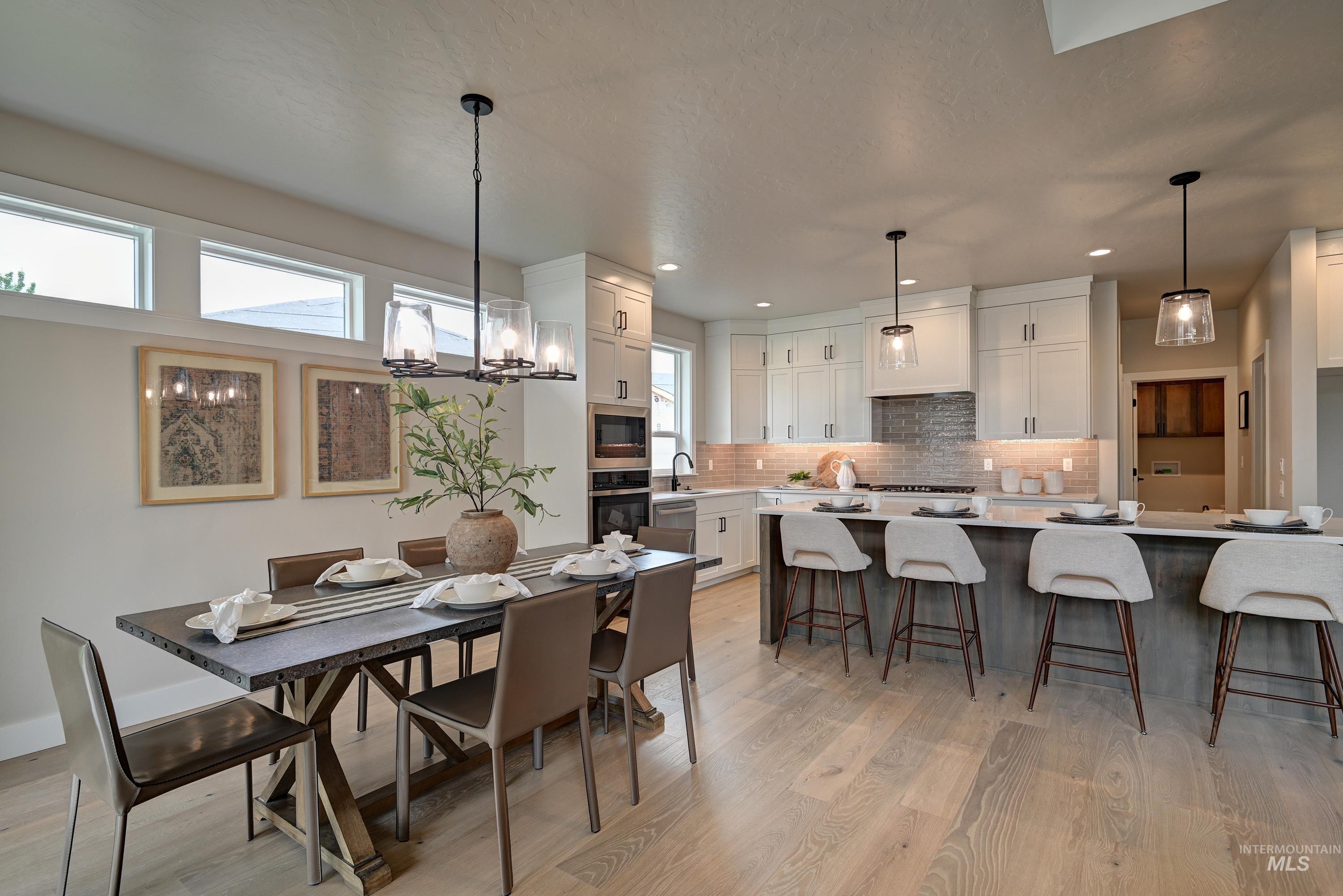 Dining room with light wood-style floors, recessed lighting, and a chandelier