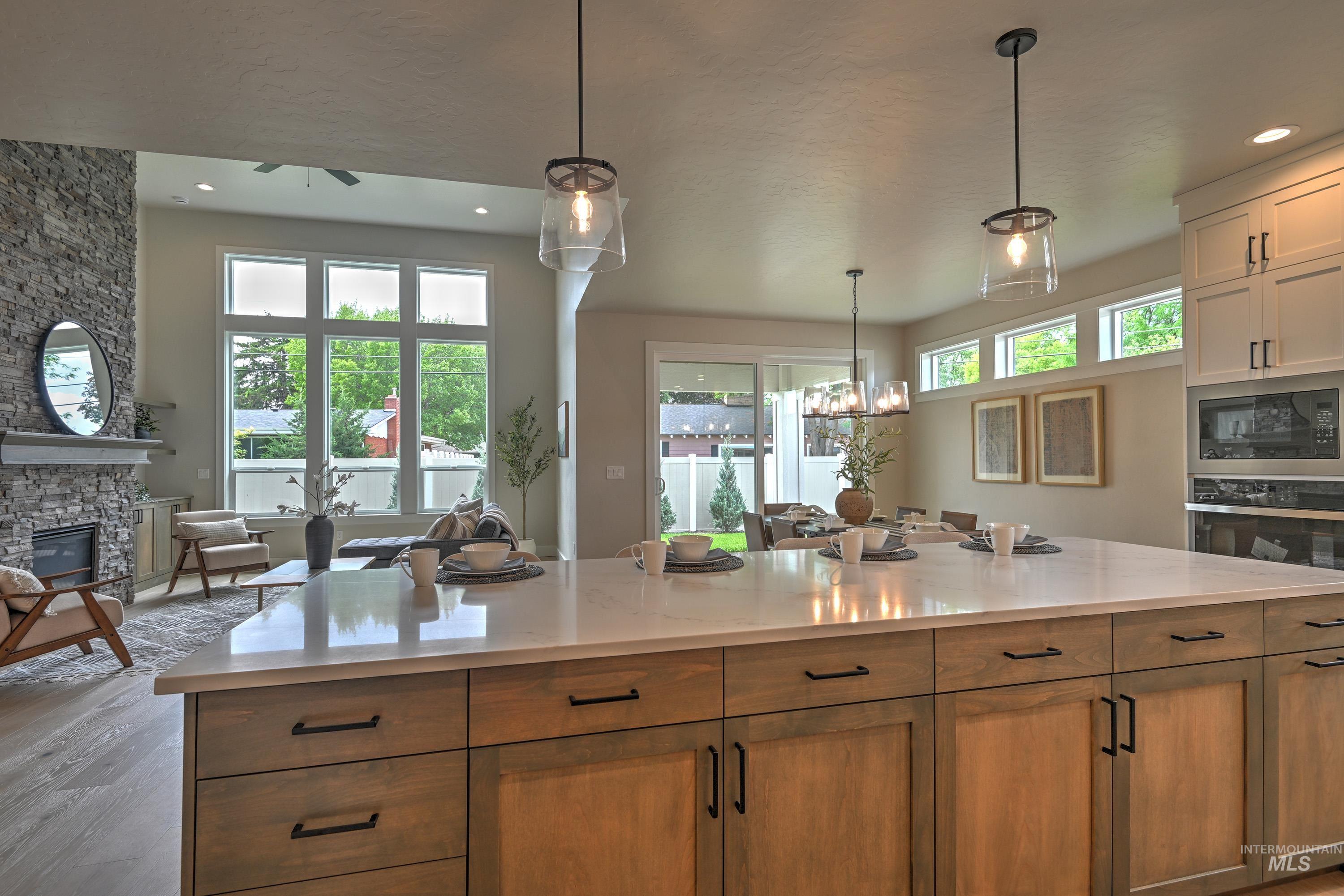 Kitchen featuring stainless steel oven, built in microwave, a fireplace, light wood finished floors, and recessed lighting
