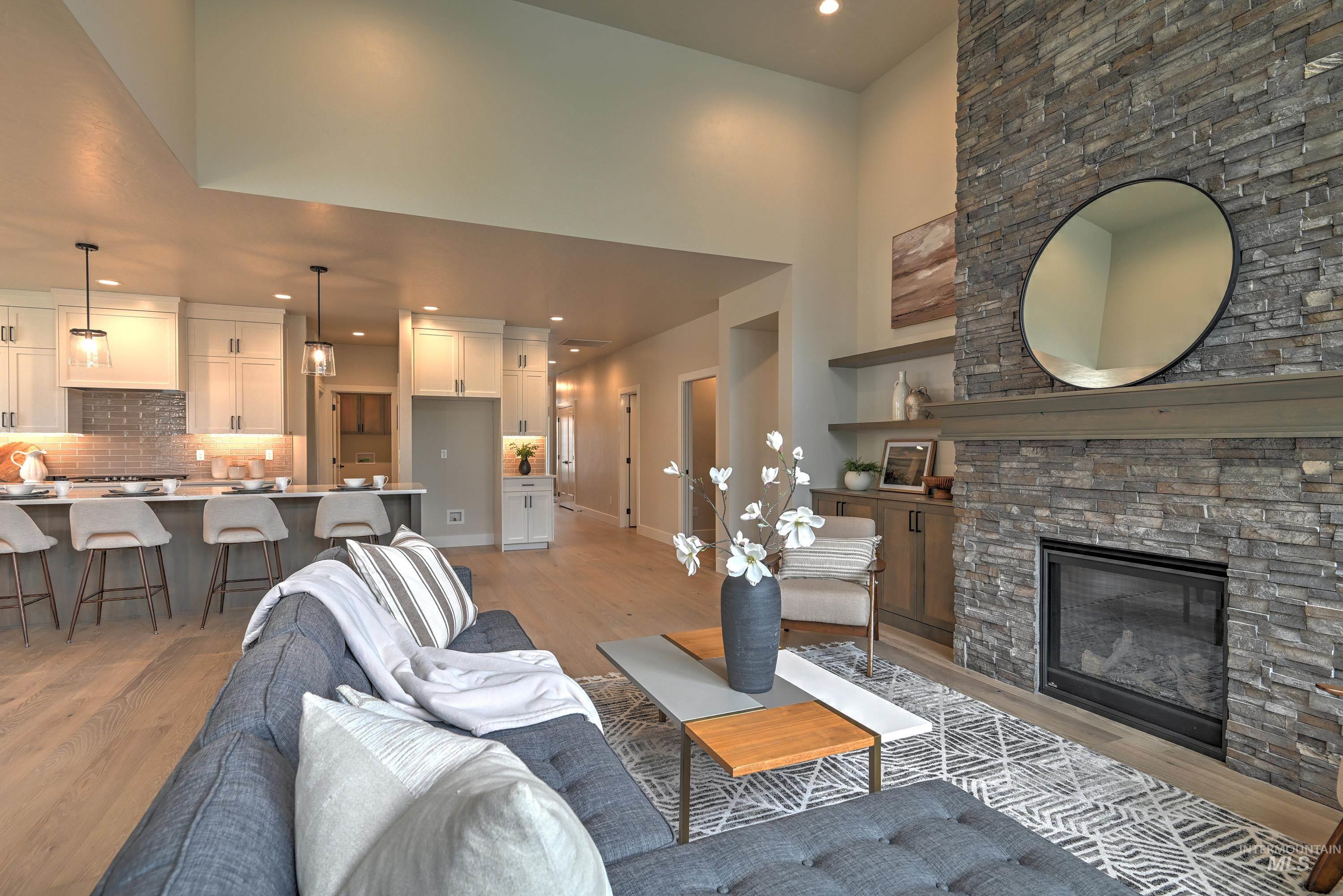 Living room with light wood-type flooring, recessed lighting, a high ceiling, and a fireplace